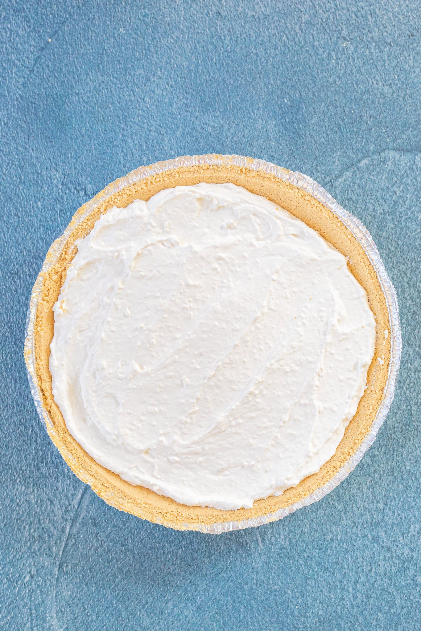 Adding the cheesecake layer to the top of the graham cracker crust