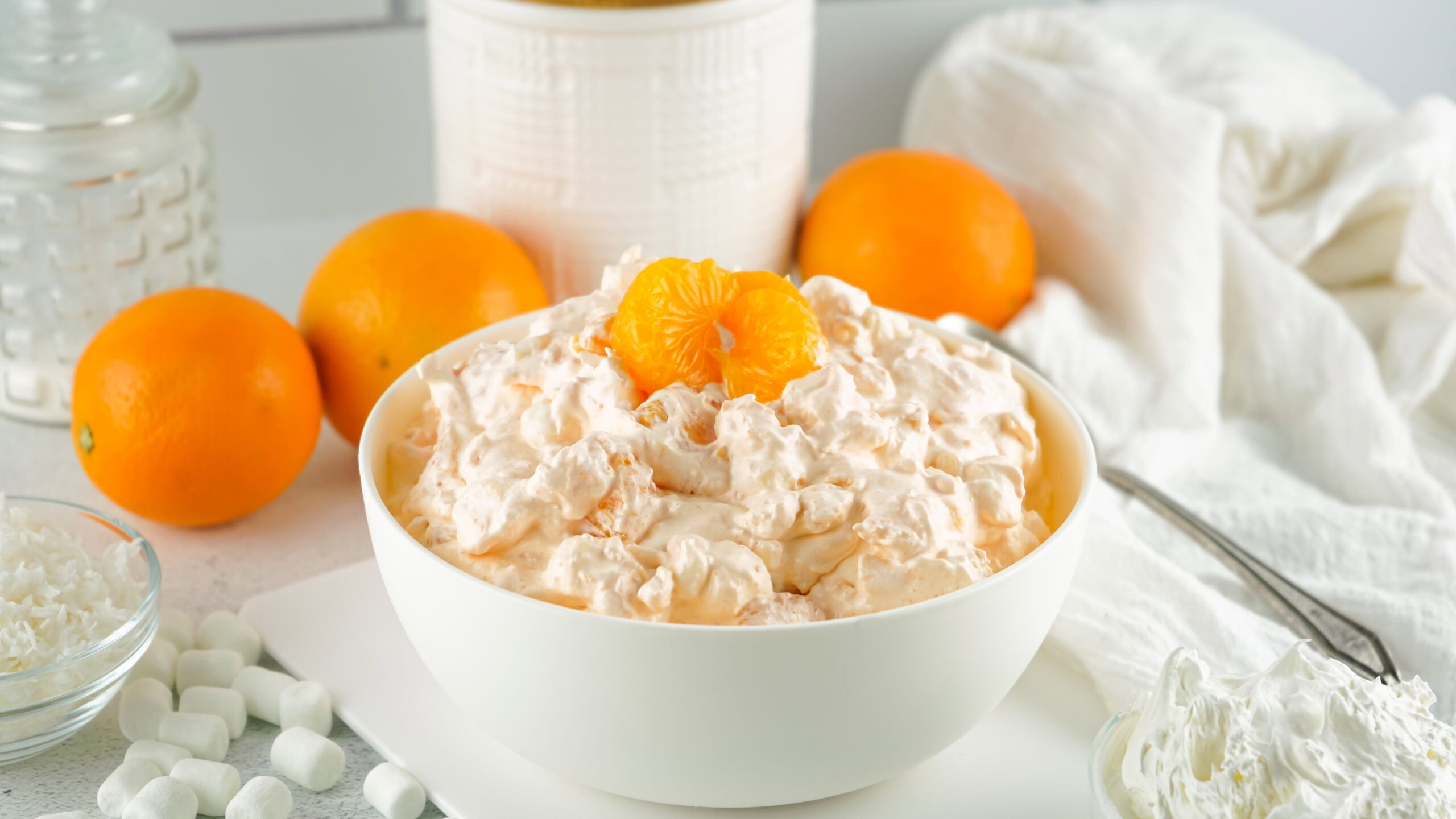 Orange fluff with cottage cheese all served up in a bowl with a spoon, ready to be enjoyed