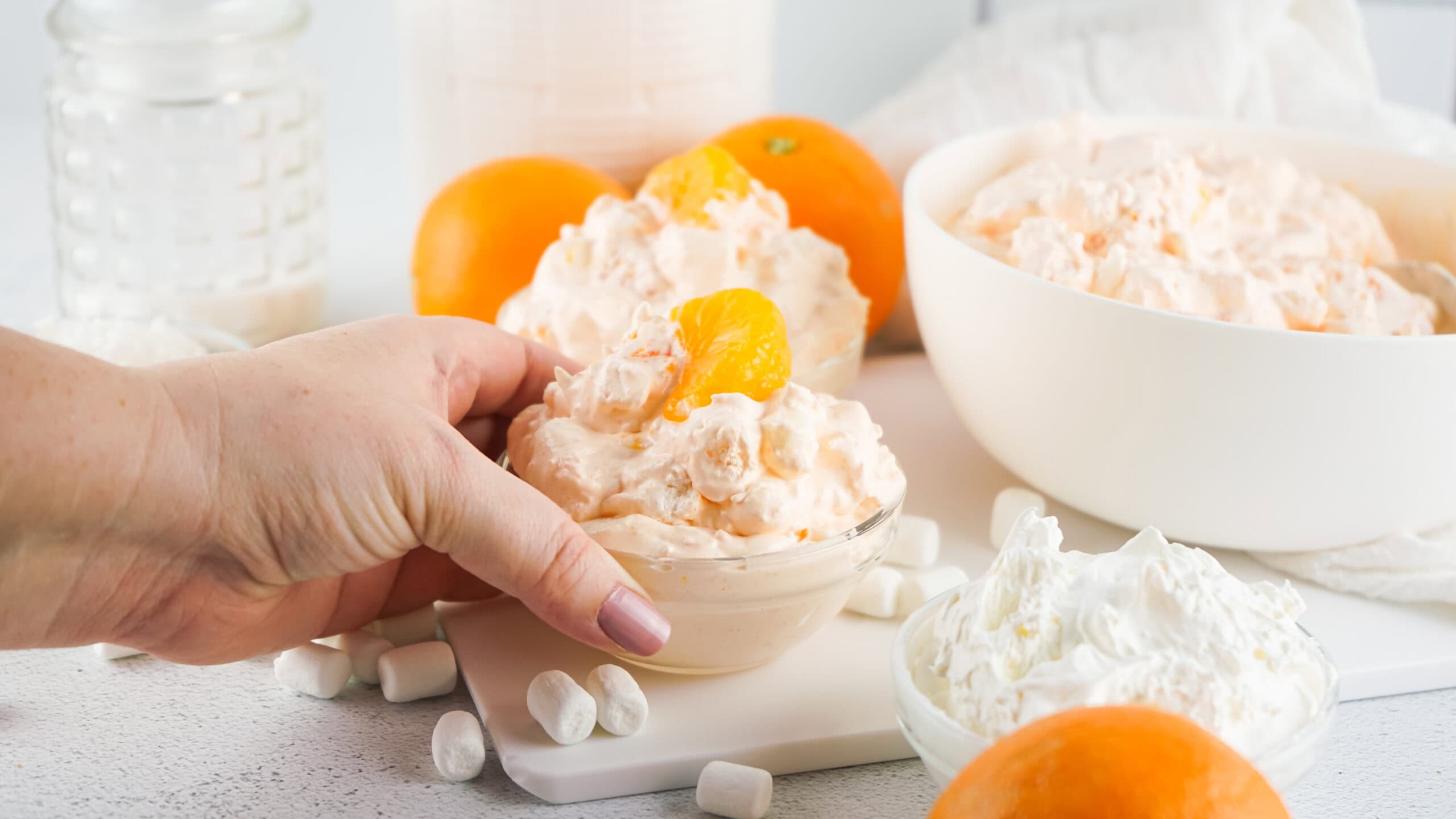 Orange fluff in a small bowl, a hand is holding the bowl, ready to be served,