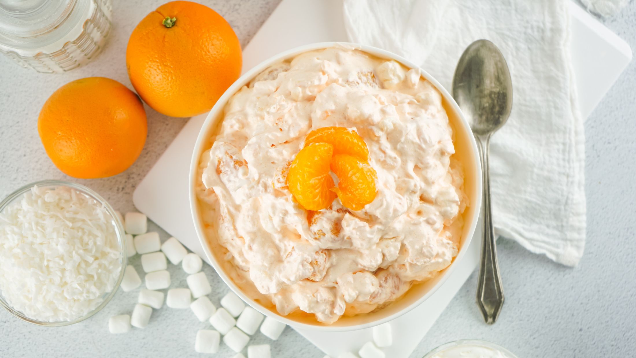 Orange fluff salad made with cottage cheese is all ready and served in a bowl with a spoon, ready to be enjoyed
