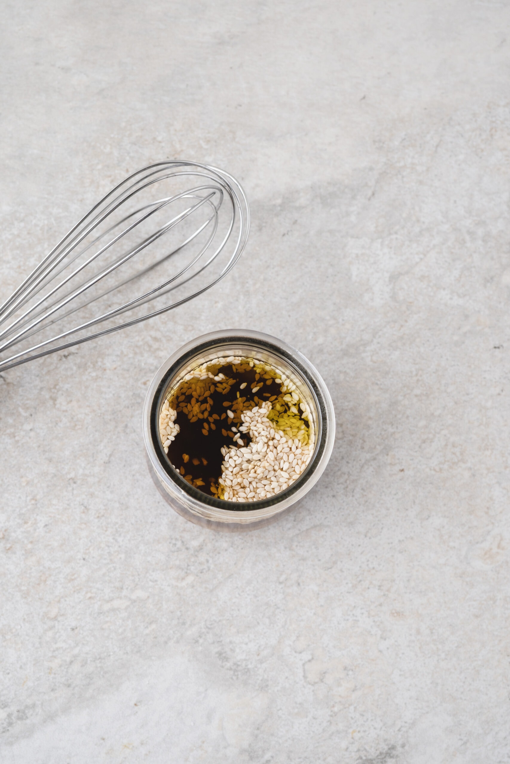 All ingredients in a small jar ready to be mixed to create sesame ginger dressing