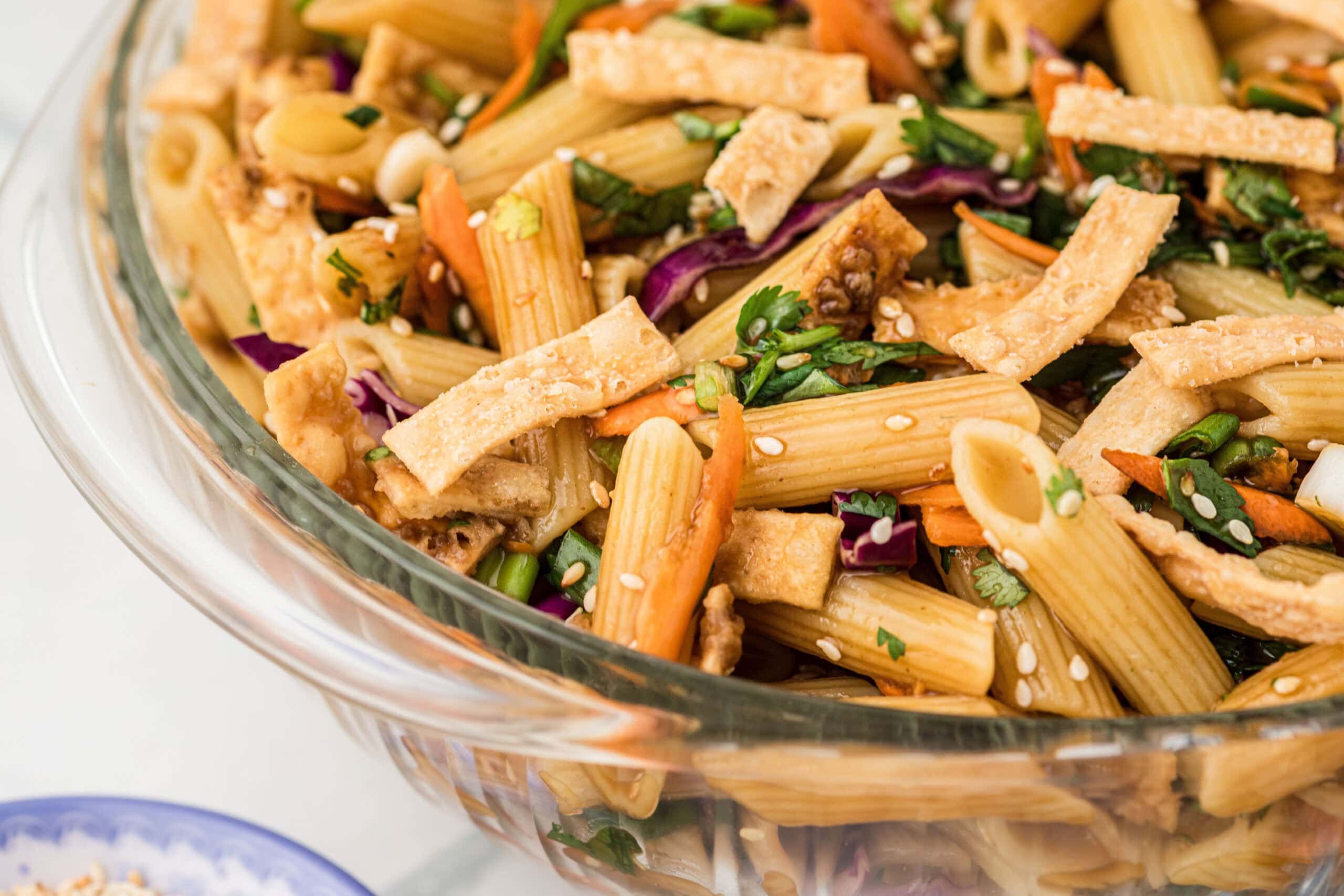 Asian Pasta Salad in clear bowl, showing a close up, side view