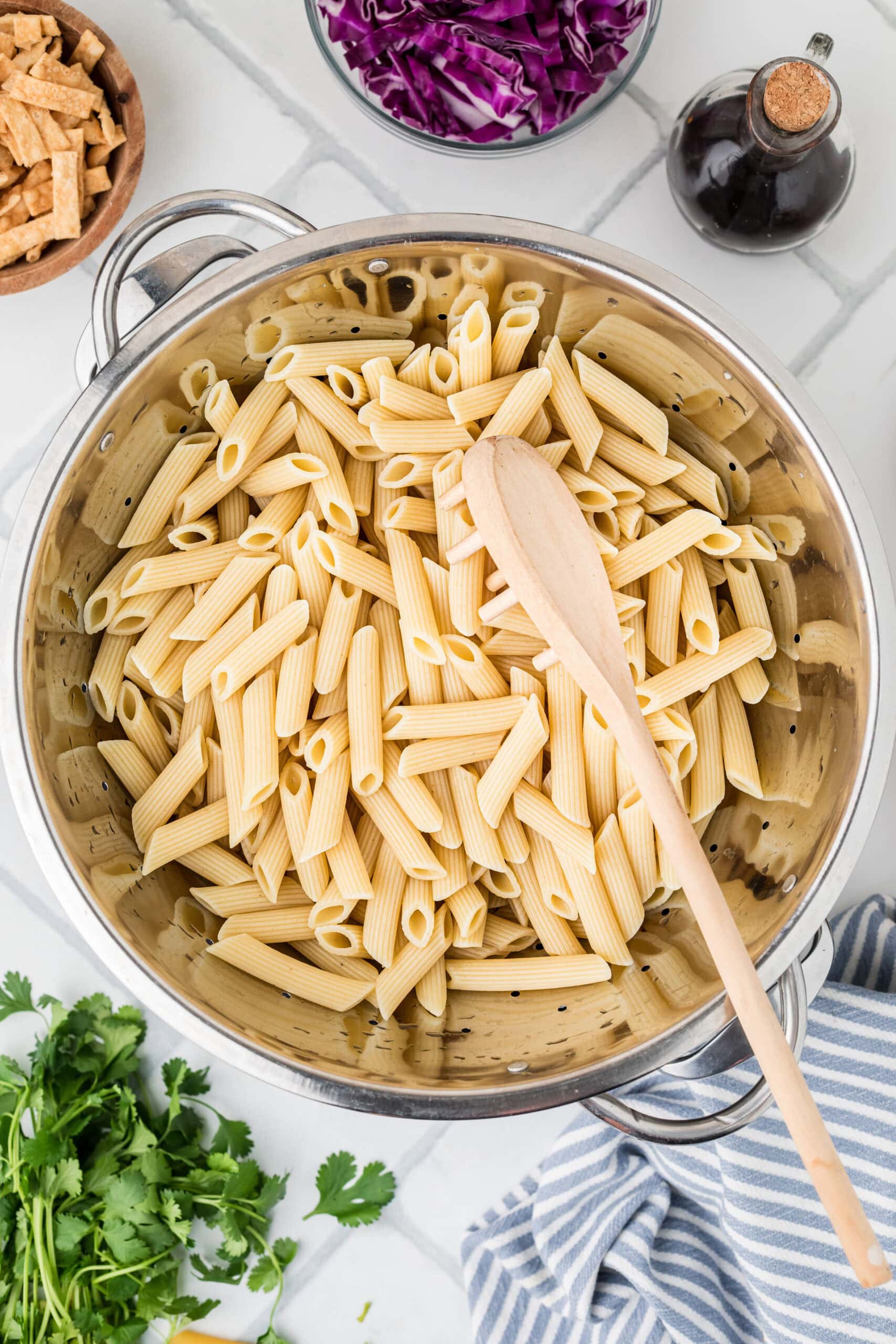 Process of cooked pasta in a pot, ready for the rest of the ingredients to finish the Asian Pasta salad.