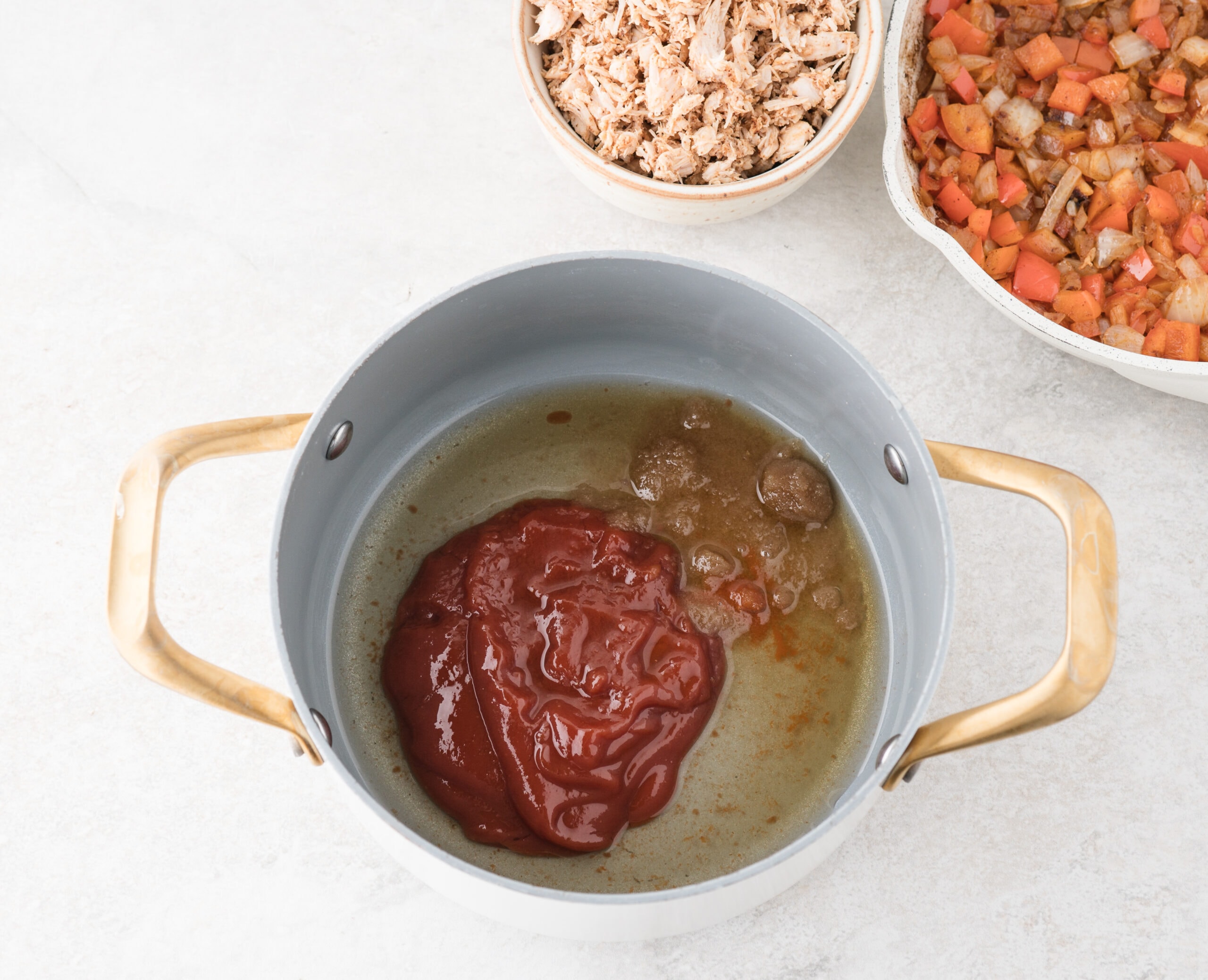Starting the process of making the BBQ sauce in a saucepan. Adding ketchup