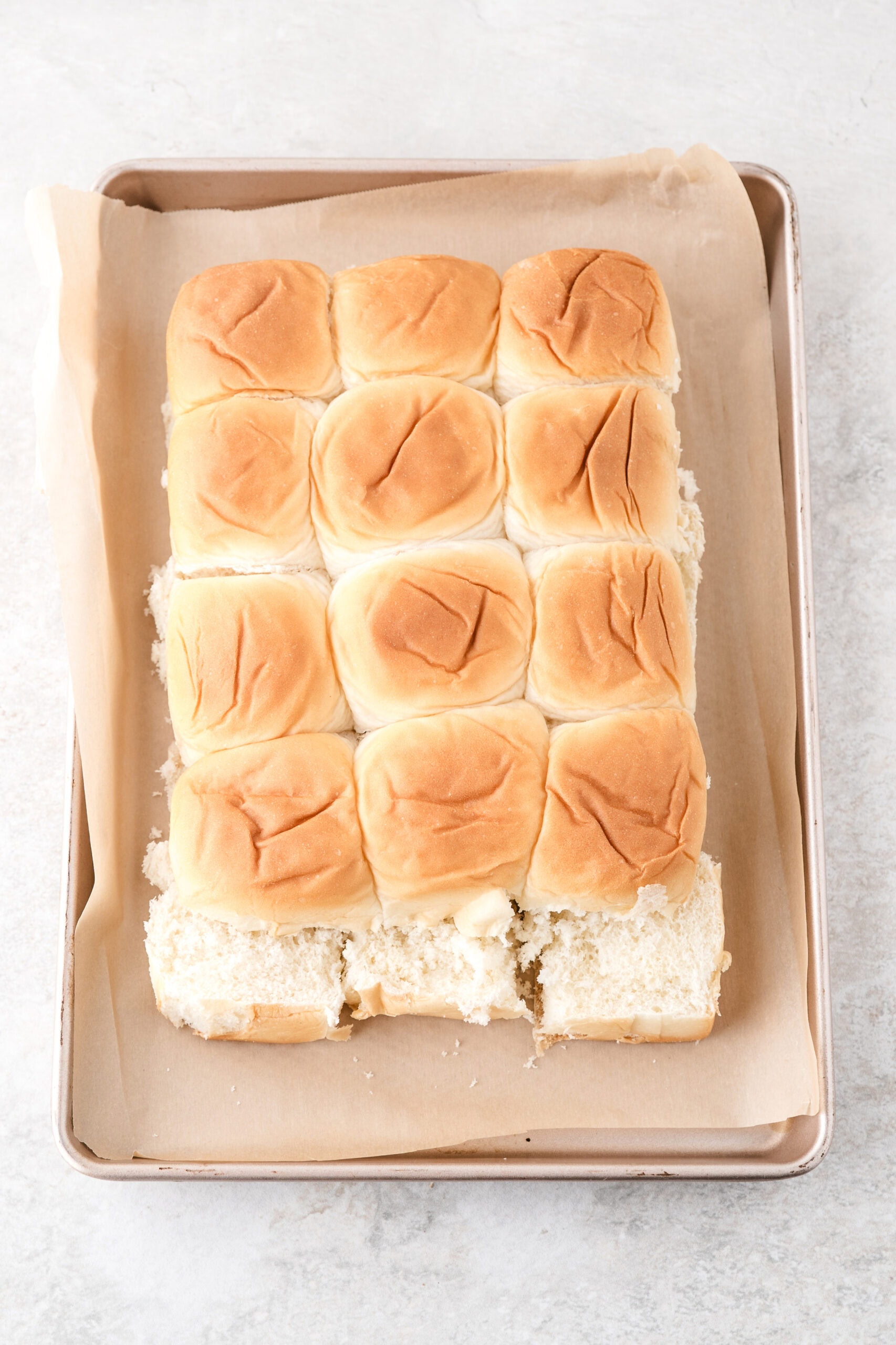 Slicing the bread buns in half to create the bbq chicken sliders.