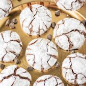 a bunch of brownie mix crinkle cookies on a gold platter with chocolate chips