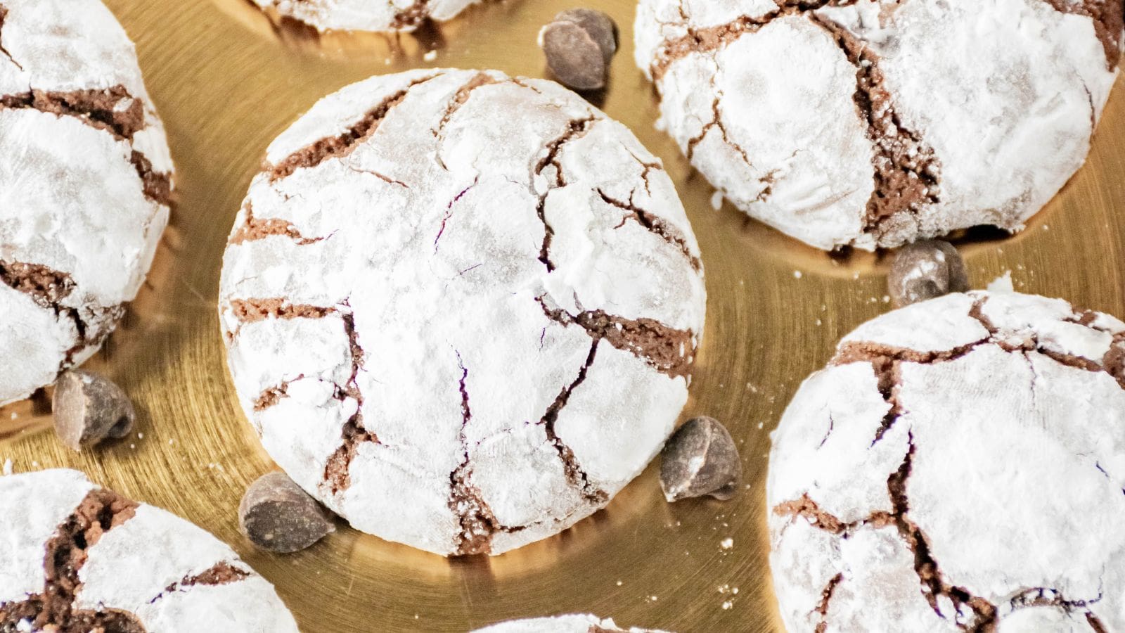 Brownie mix crinkle cookies on a gold tray with chocolate chips