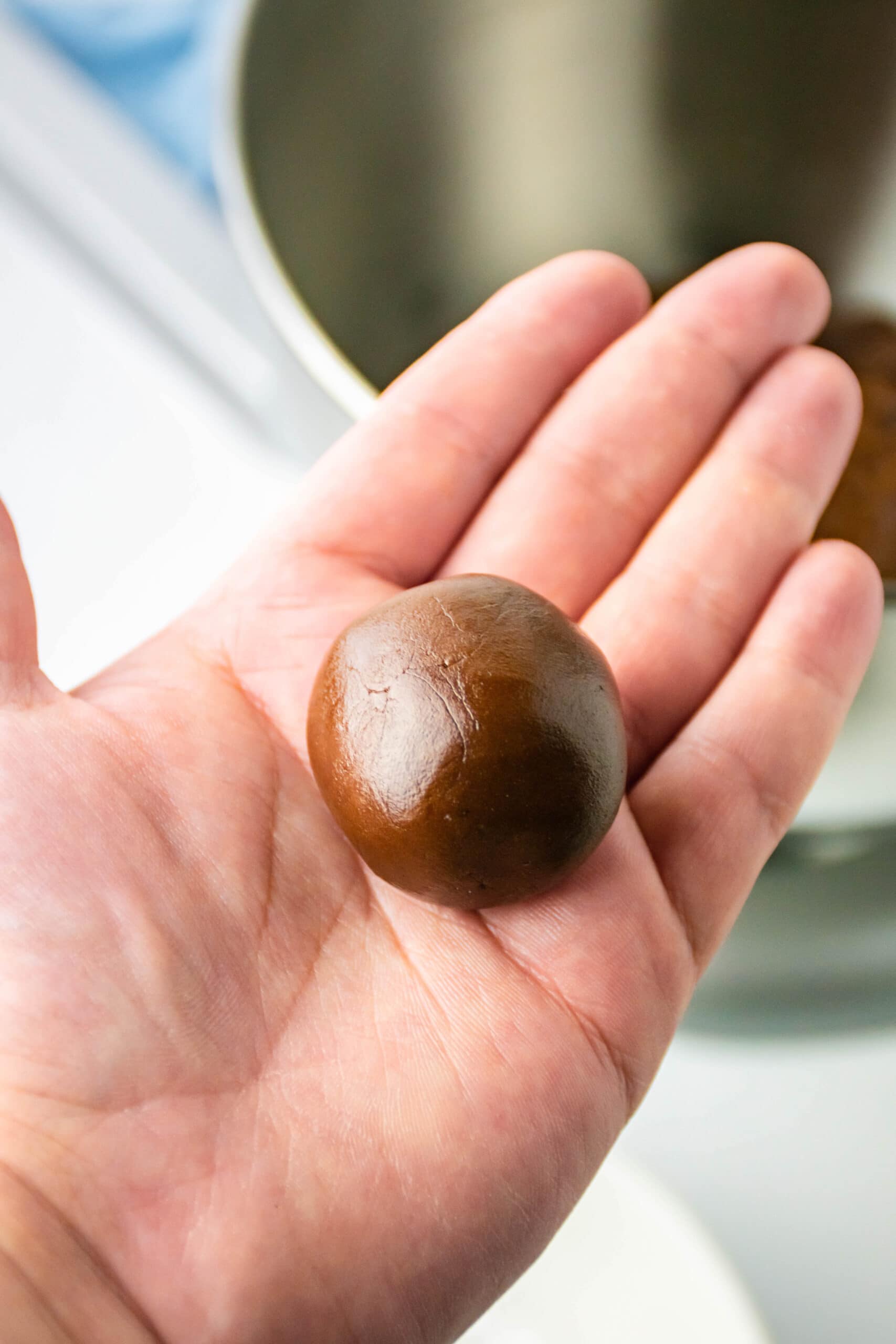 Shaping the brownie cookie batter into balls in palm of hand