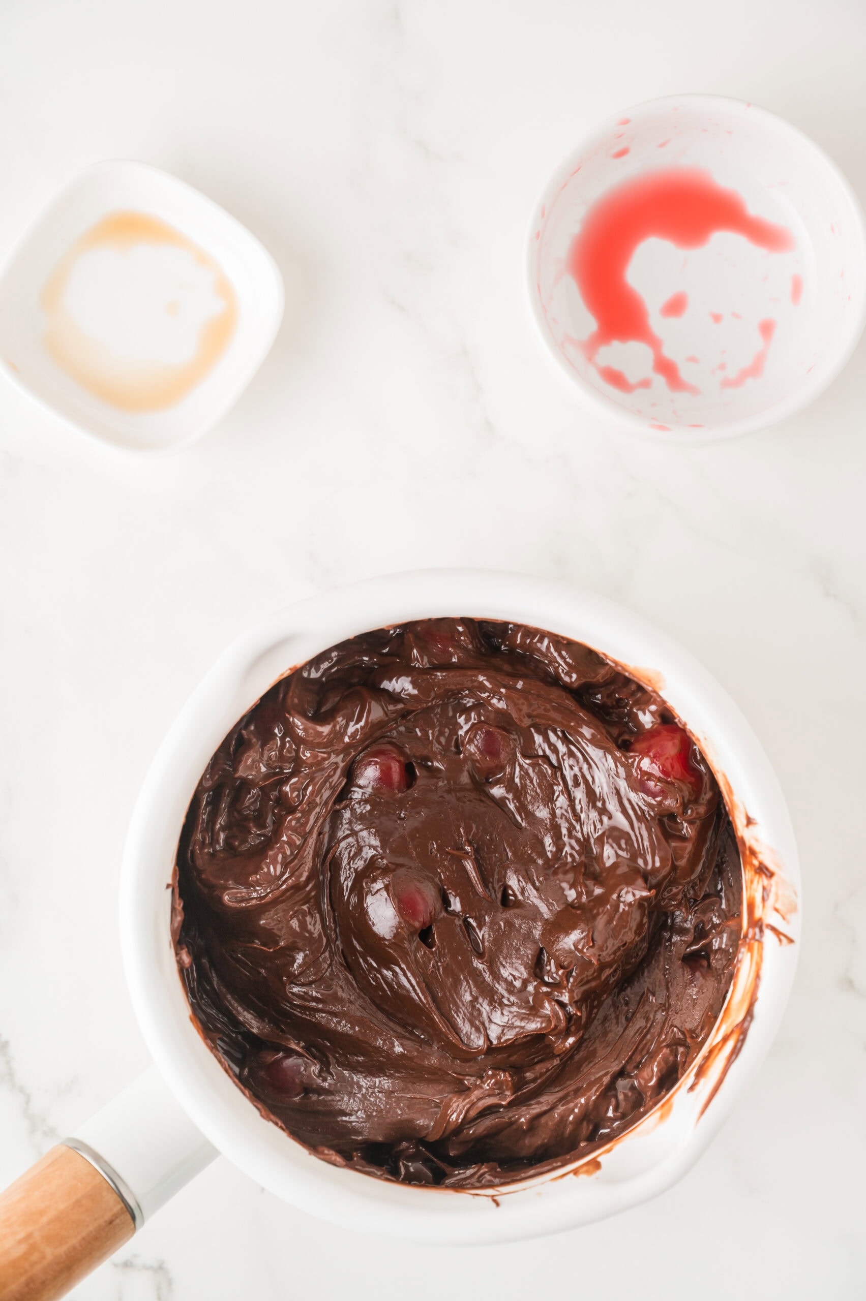 The process of mixing cherries into the chocolate batter