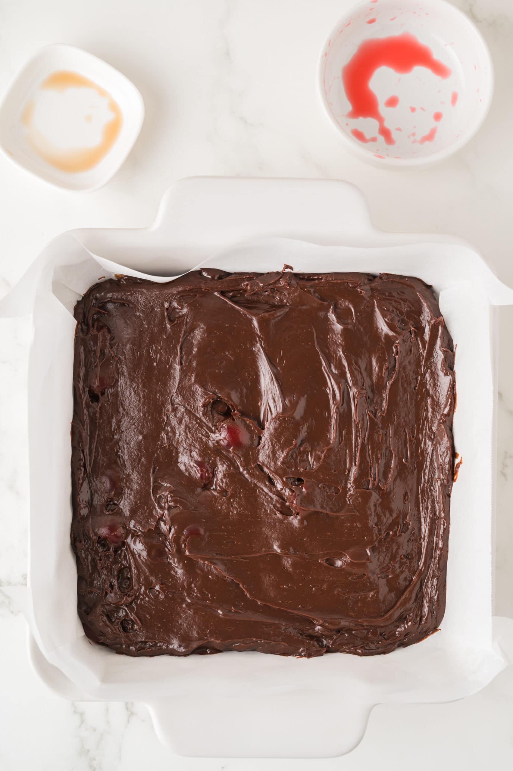 Process of dark cherry fudge almost completed by adding it to the baking dish and smoothed on top