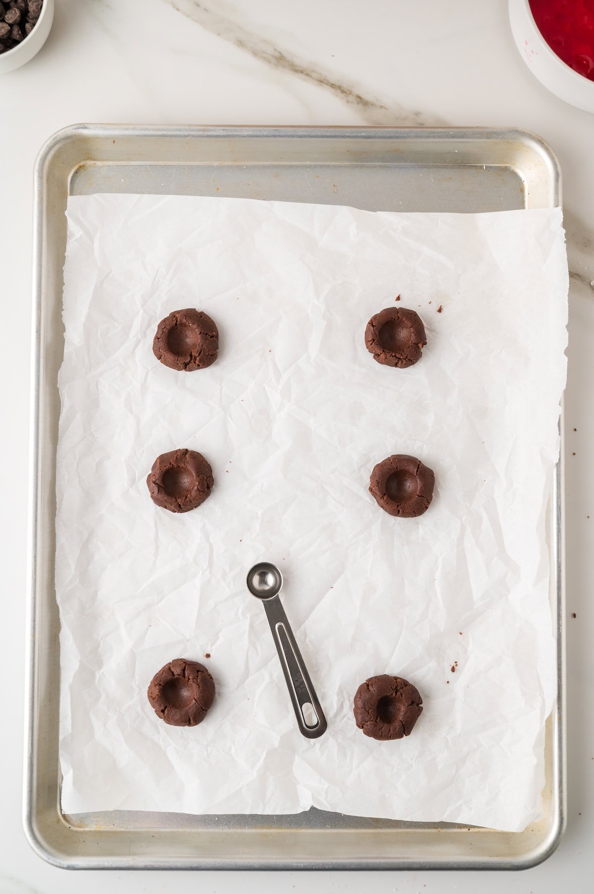 use a small round teaspoon to make thumbprints in the chocolate cookie dough