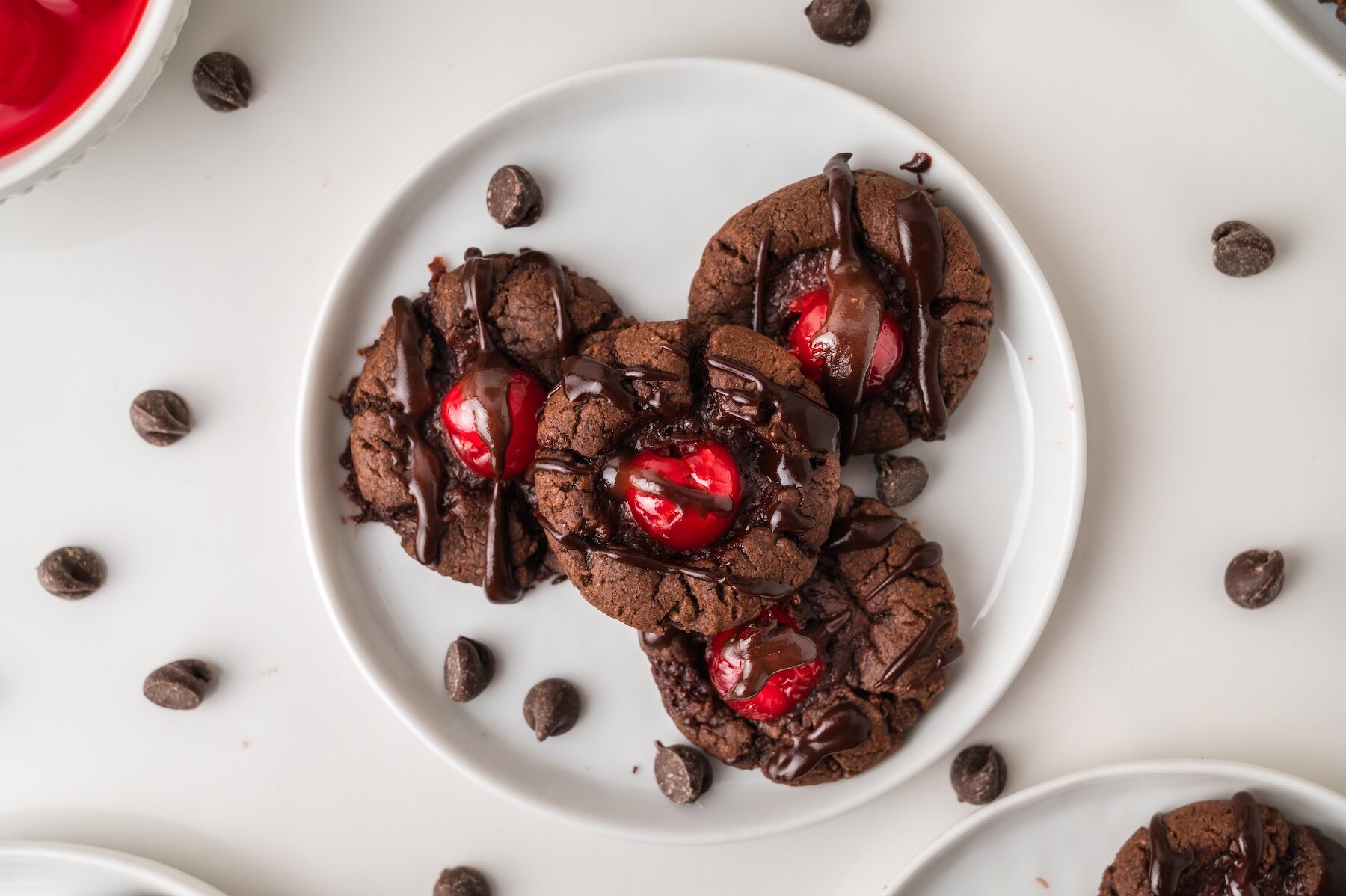 four Chocolate Covered Cherry Cookies on a white plate