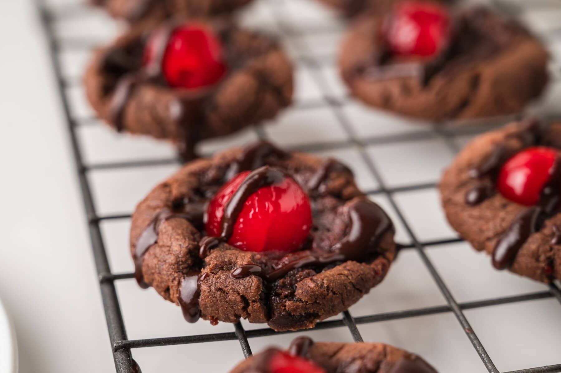 a close up of Chocolate Cherry Cookies on a wire rack