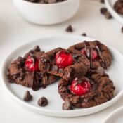 a stack of four cherry chocolate cookies, one with a bite taken out