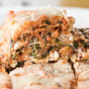 a close up of one piece of veggie lasagna showing zucchini, broccoli, cheese, and noodles