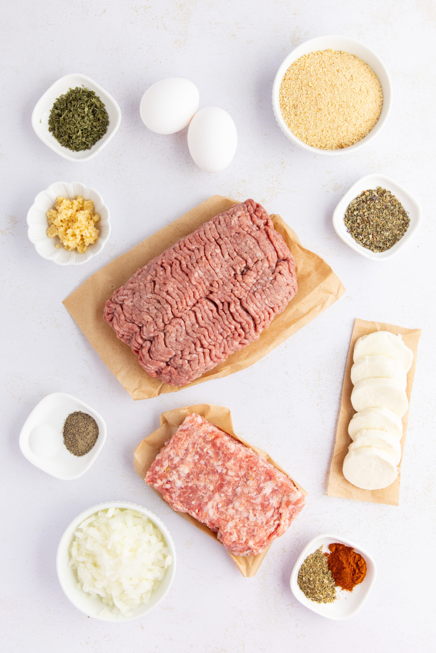All ingredients pictured: ground beef, Italian sausage, breadcrumbs, egg, onion, garlic, parsley, basil, paprika, salt, pepper , mozzarella