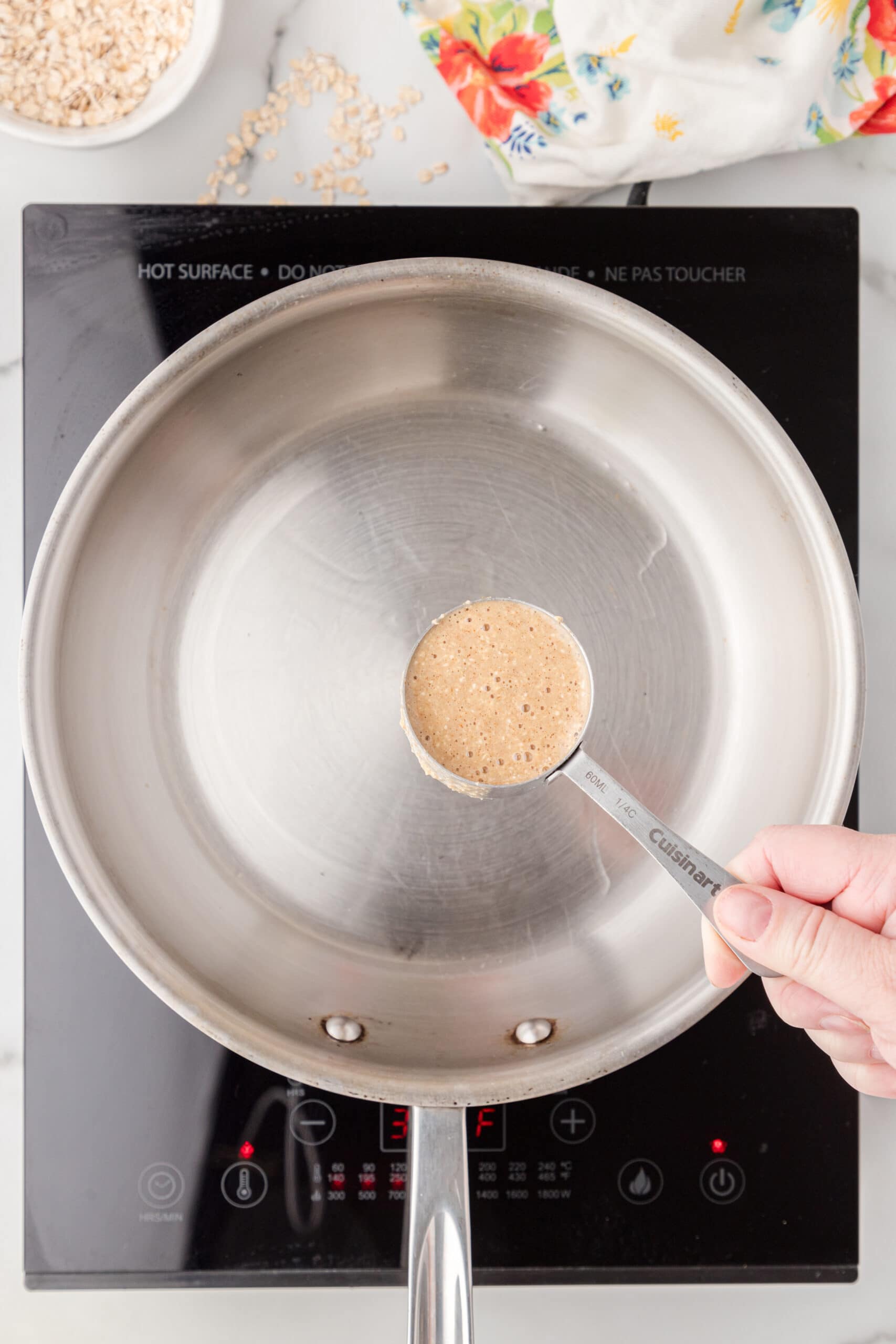 ¼ cup being shown with banana protein batter in it to start making pancakes