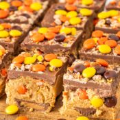 a close up of Reese's No Bake peanut butter bars made with chocolate, peanut butter, Reese's Pieces, and Reese's Peanut Butter Cups