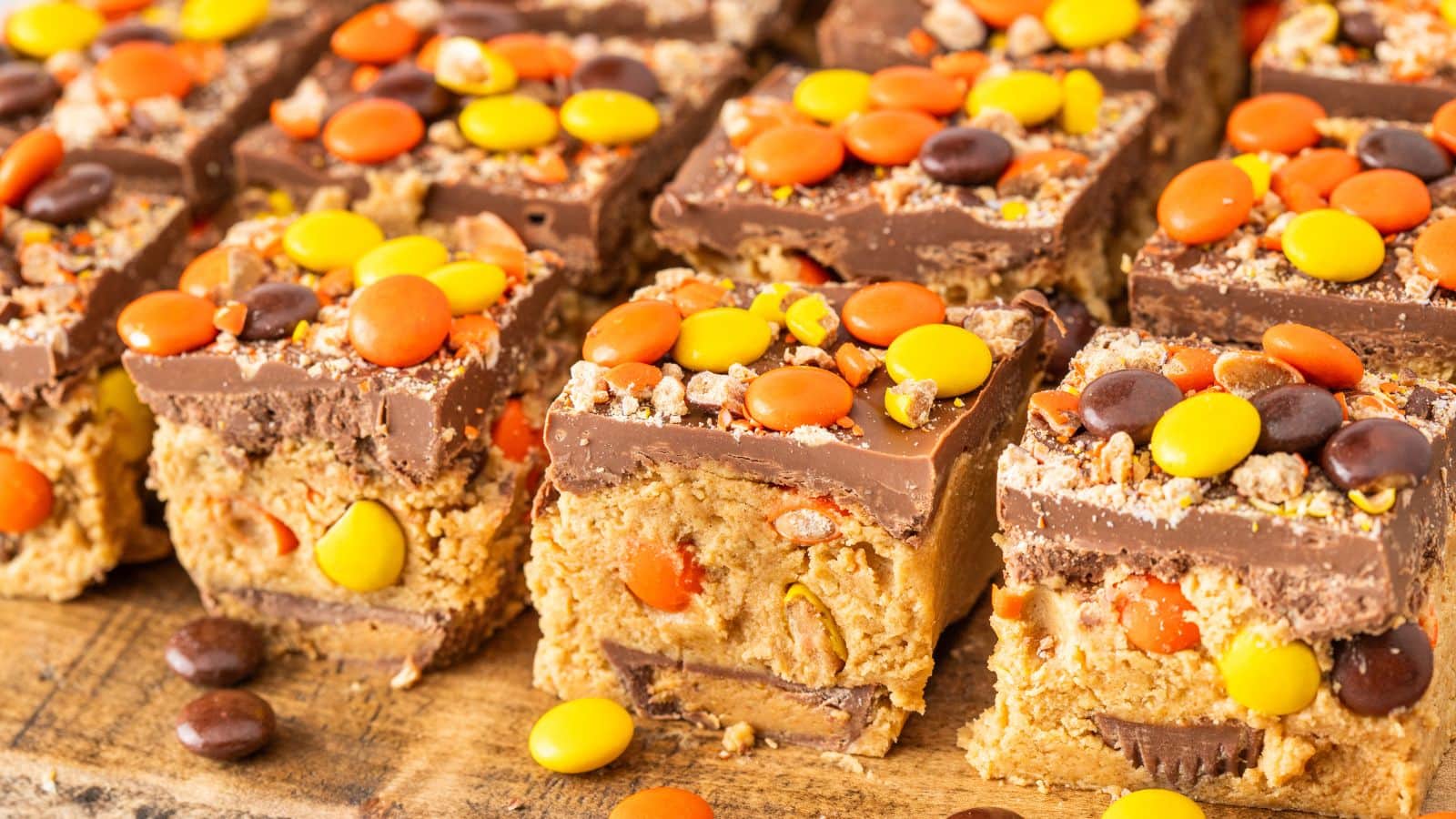 a lot of Reese's No Bake peanut butter bars made with chocolate, peanut butter, Reese's Pieces, and Reese's Peanut Butter Cups