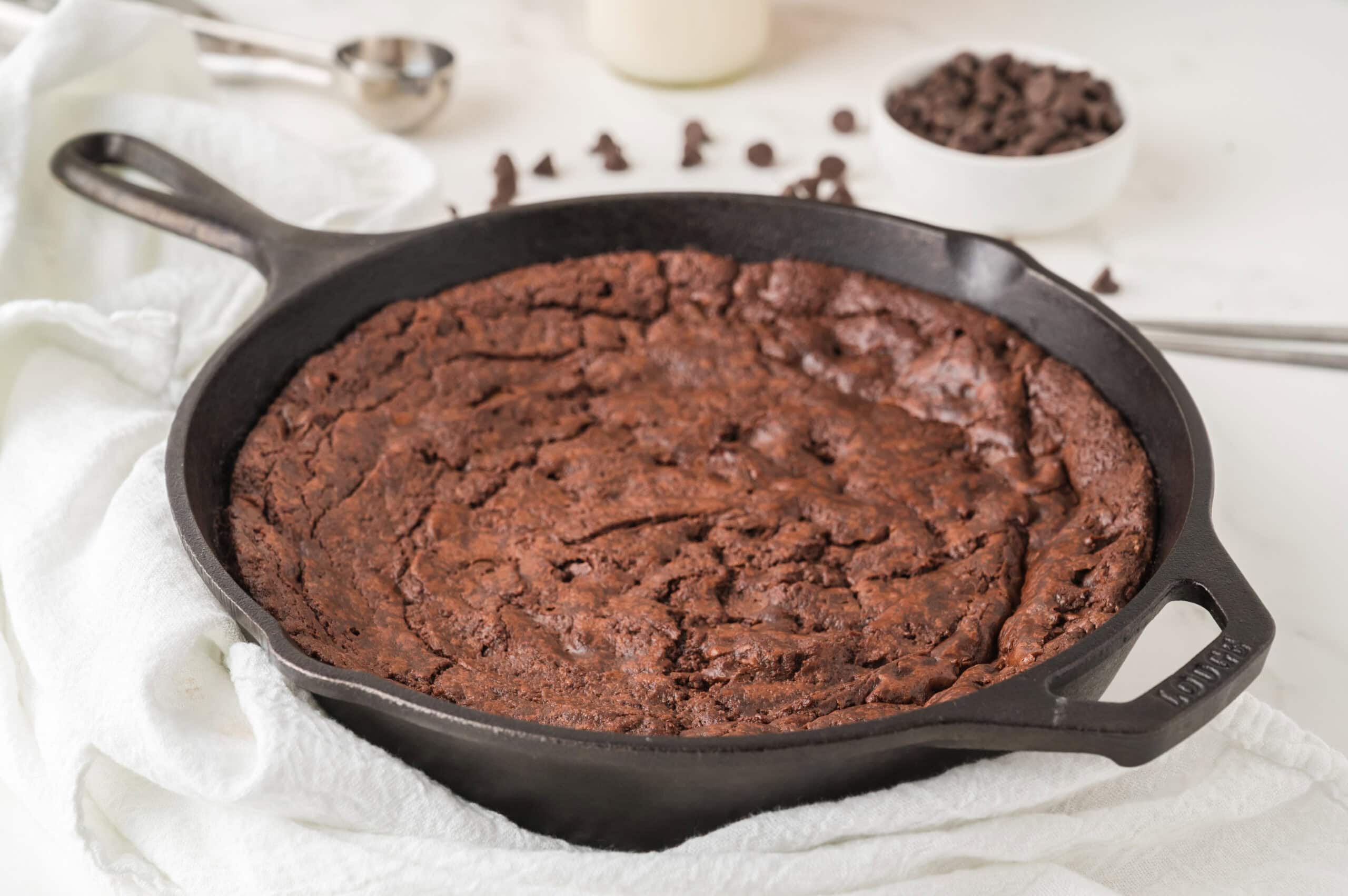 Brownie skillet cooling from baking. All ready to add toppings: vanilla ice cream and chocolate drizzle