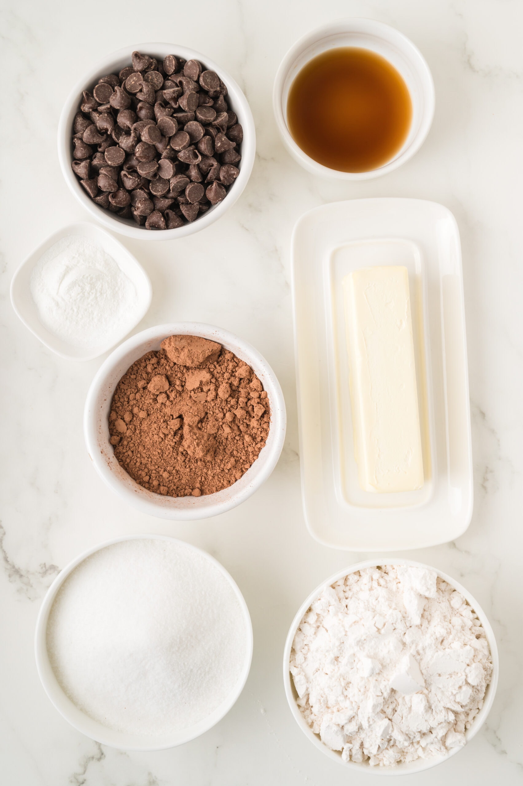 All ingredients pictured: flour, baking powder, cocoa powder, chocolate chips, vanilla bean paste