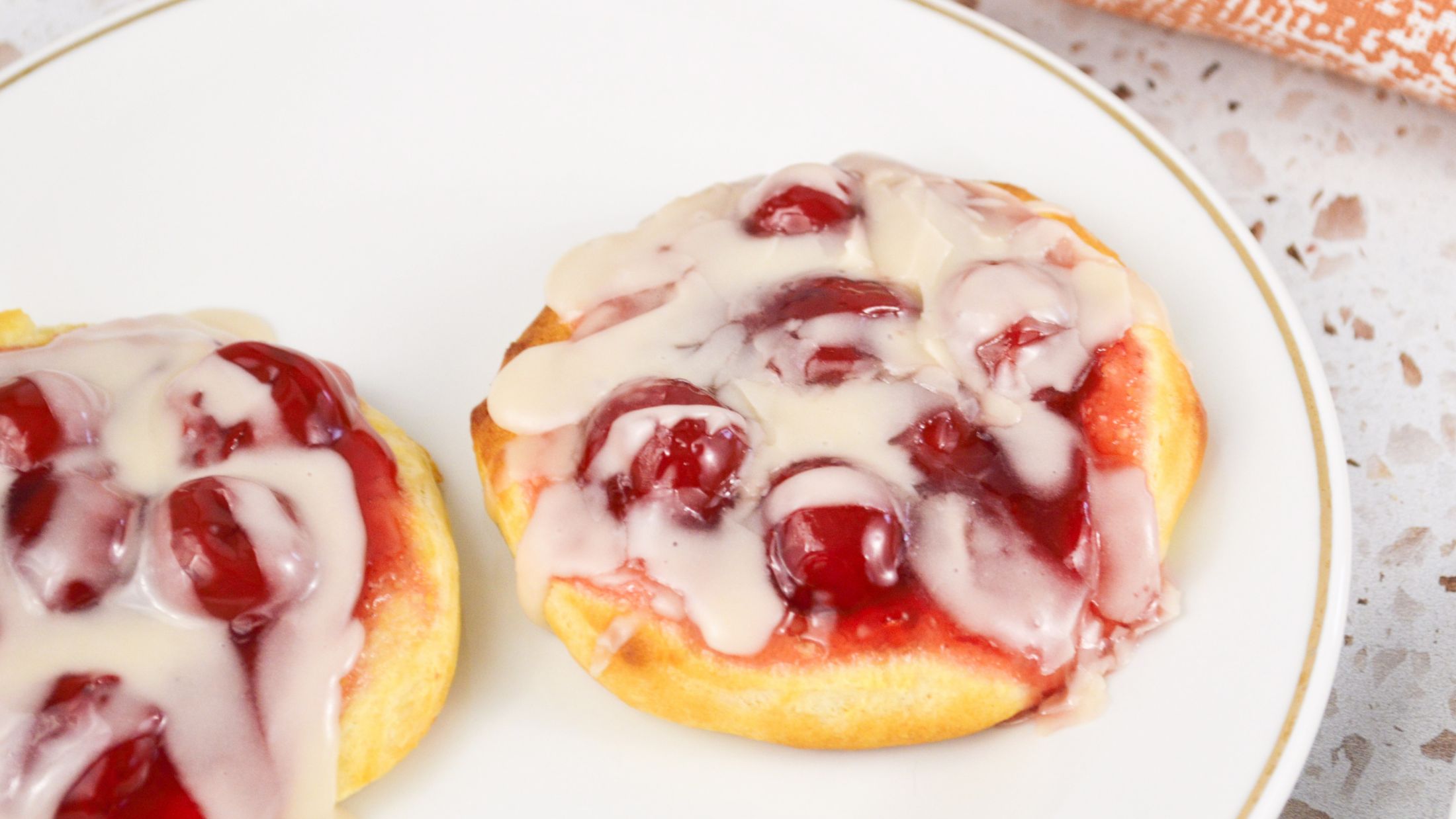 Cherry danish with almond glaze plated and ready to be enjoyed