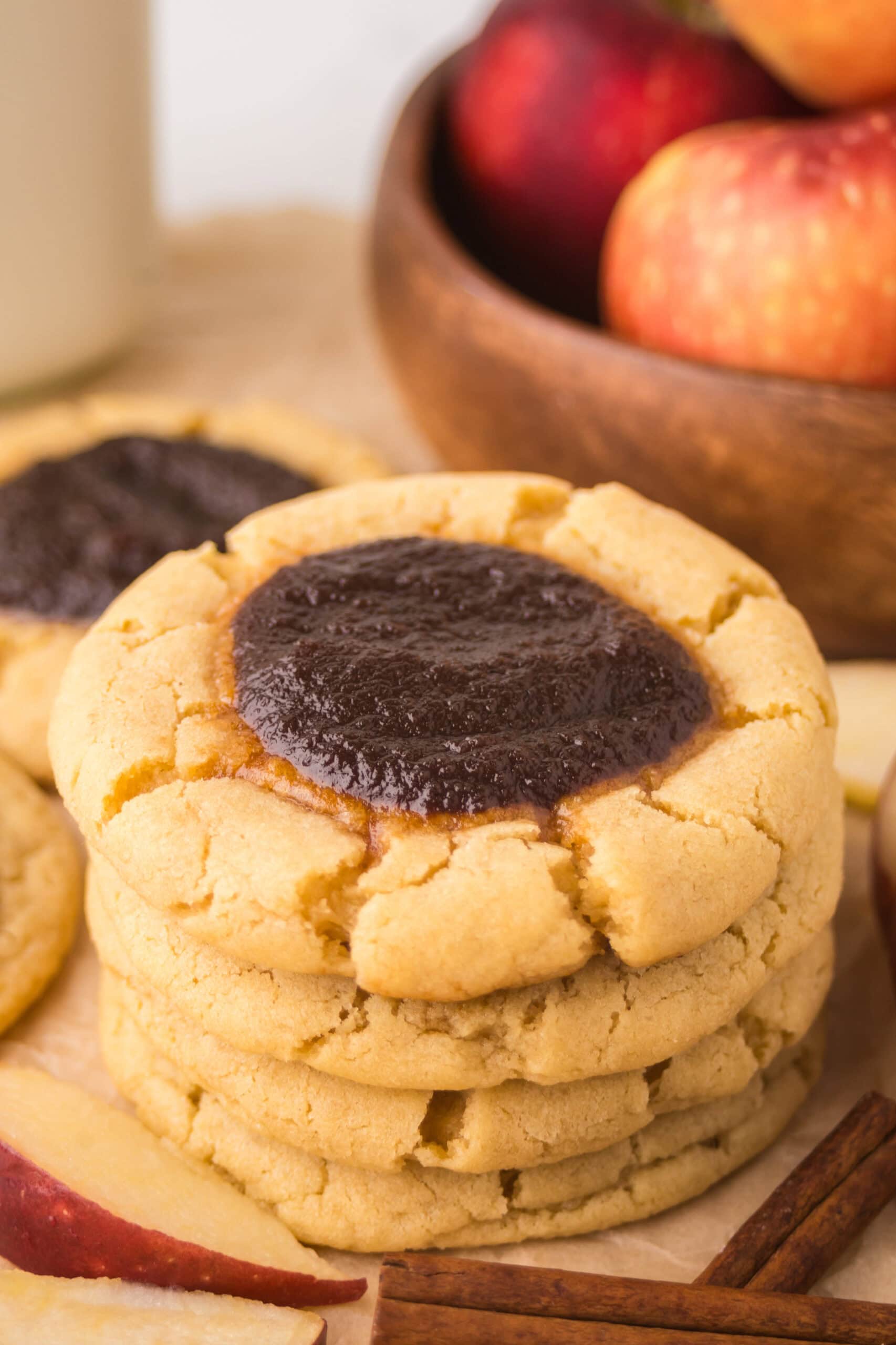 A stack of baked apple butter thumbprint cookies, showing the texture of the apple butter