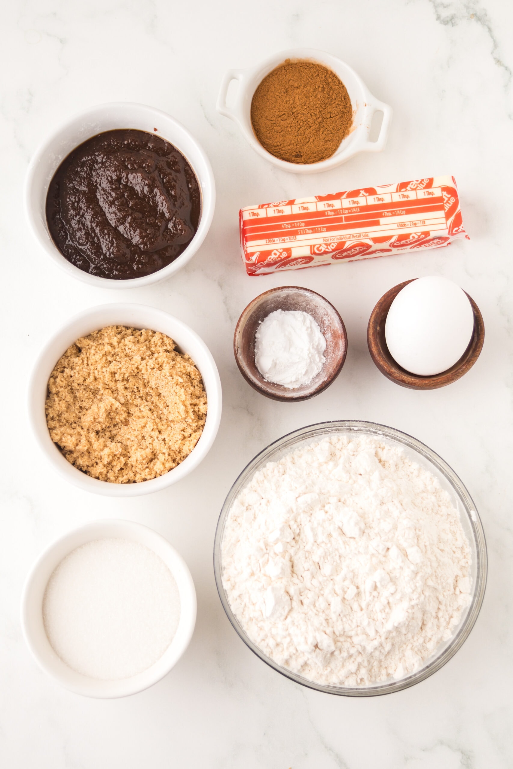 All ingredients are pictured: unsalted butter, brown sugar, white granulated sugar, egg, baking soda, baking powder, apple butter, flour