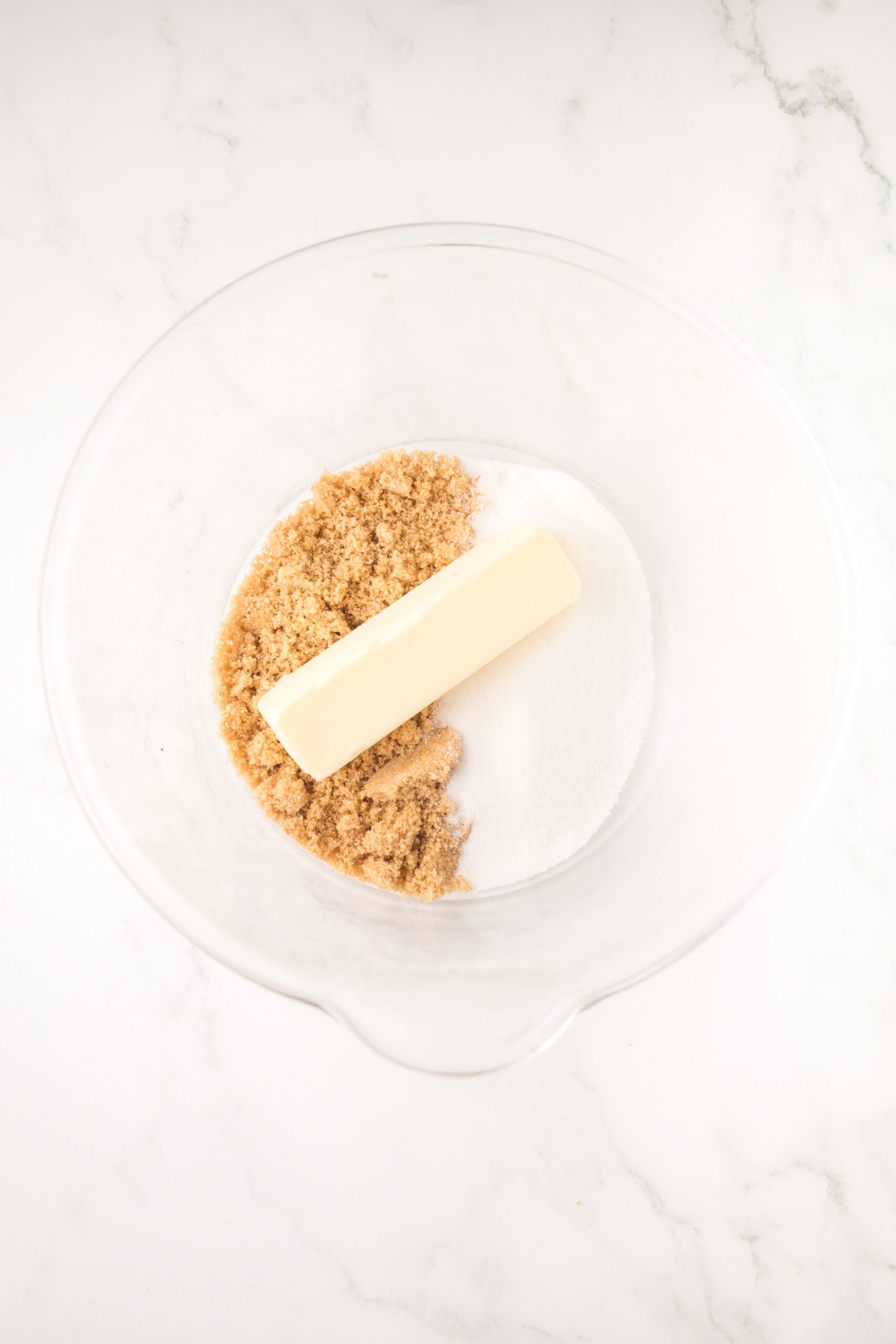 Adding the unsalted butter with brown and white sugar in a mixing bowl.