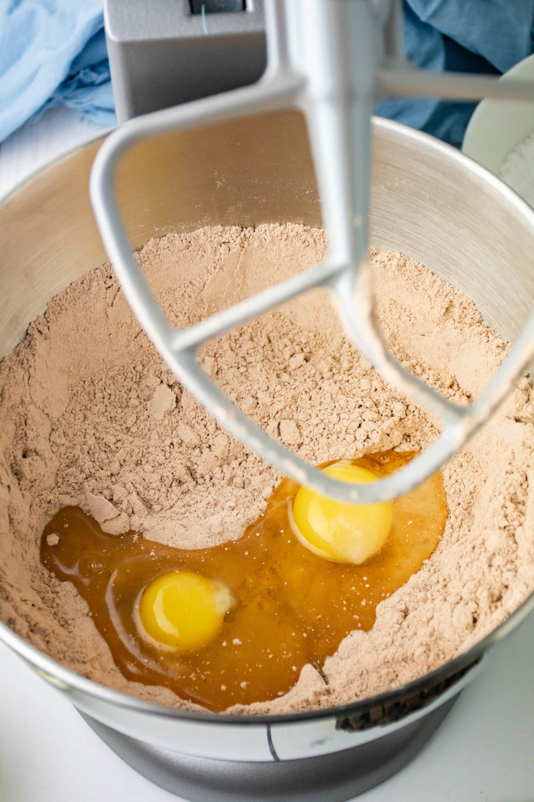 Adding eggs to the dry ingredients in mixing bowl