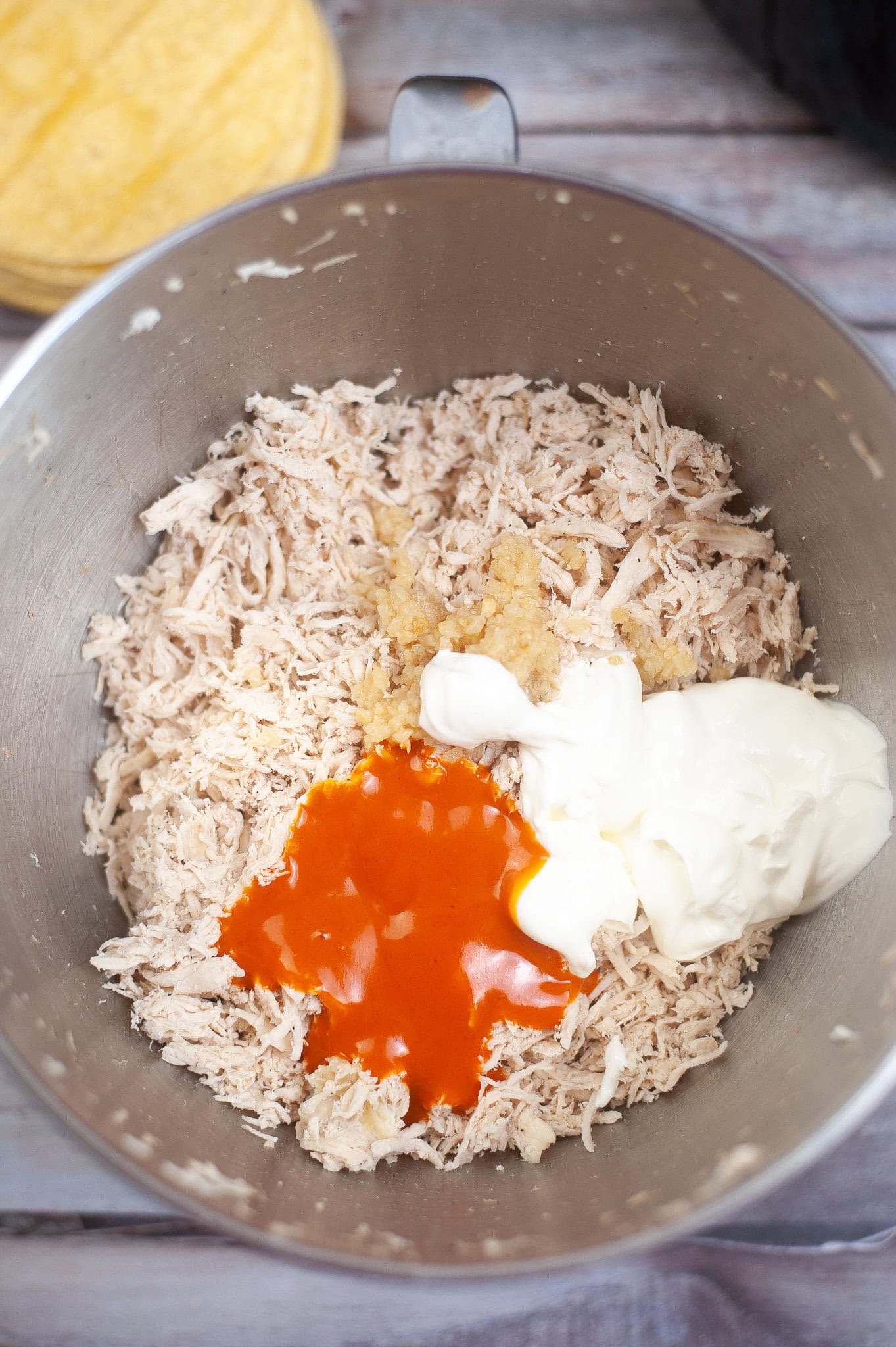 Preparing the chicken mixture: shredded chicken, ranch, hot sauce, and garlic. Ready to be mixed all together