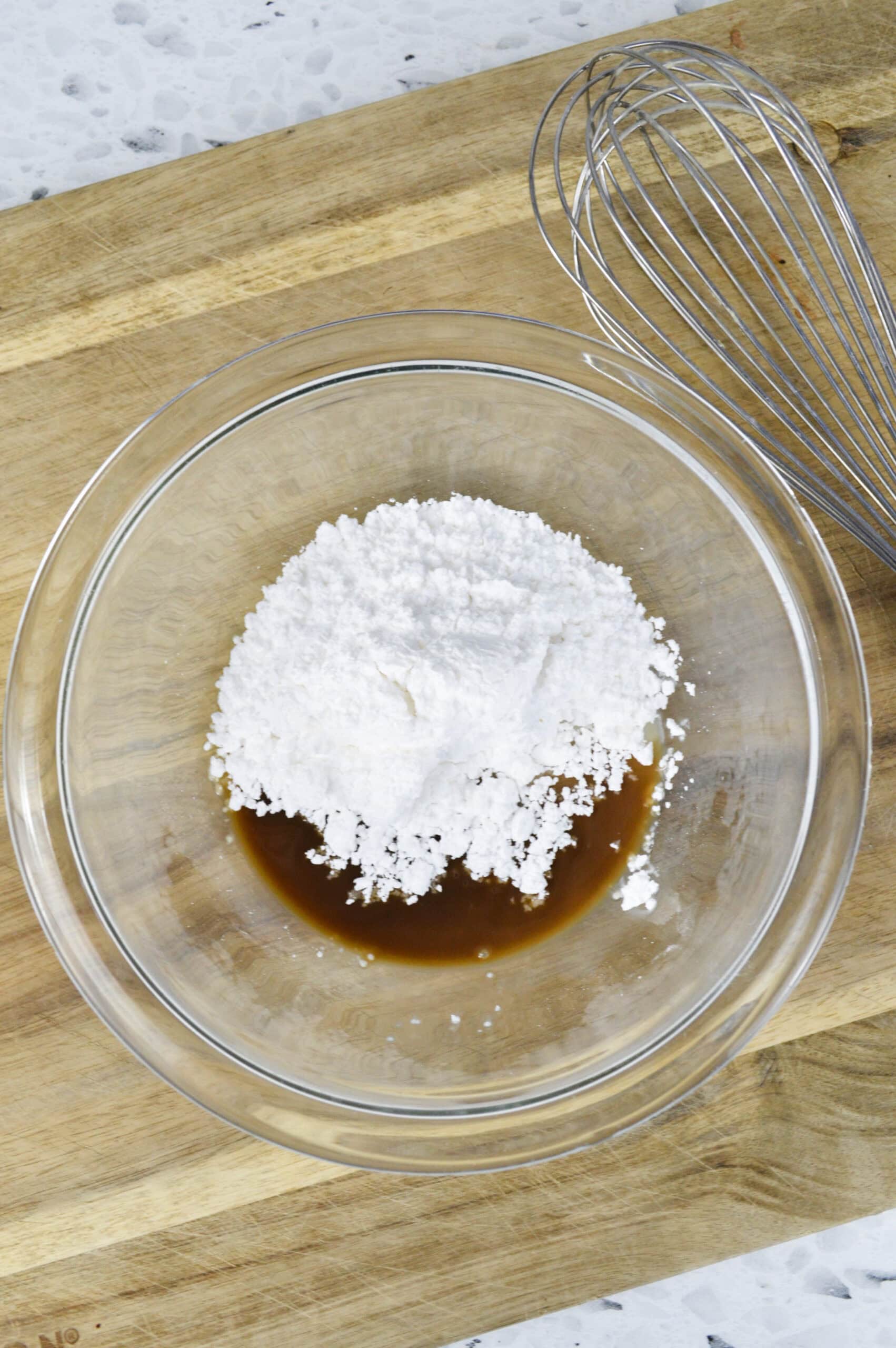 Ingredients in bowl to make the almond glaze: almond extract, milk and powdered sugar