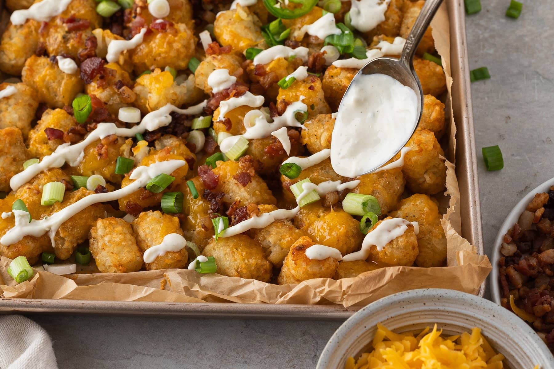 drizzle ranch sour cream over the loaded tater tots