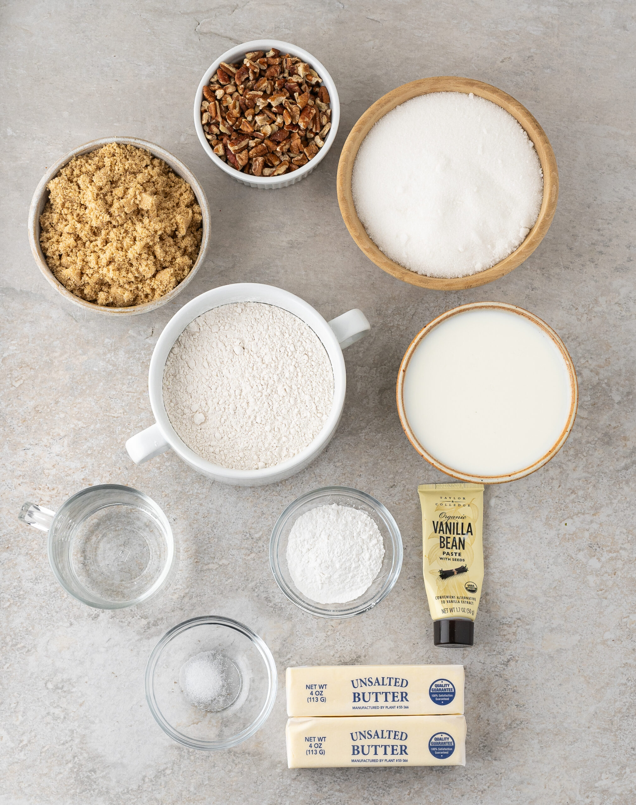 All ingredients pictured: salt, butter, vanilla bean paste, flour, pecans, granulated sugar, brown sugar, milk, baking powder