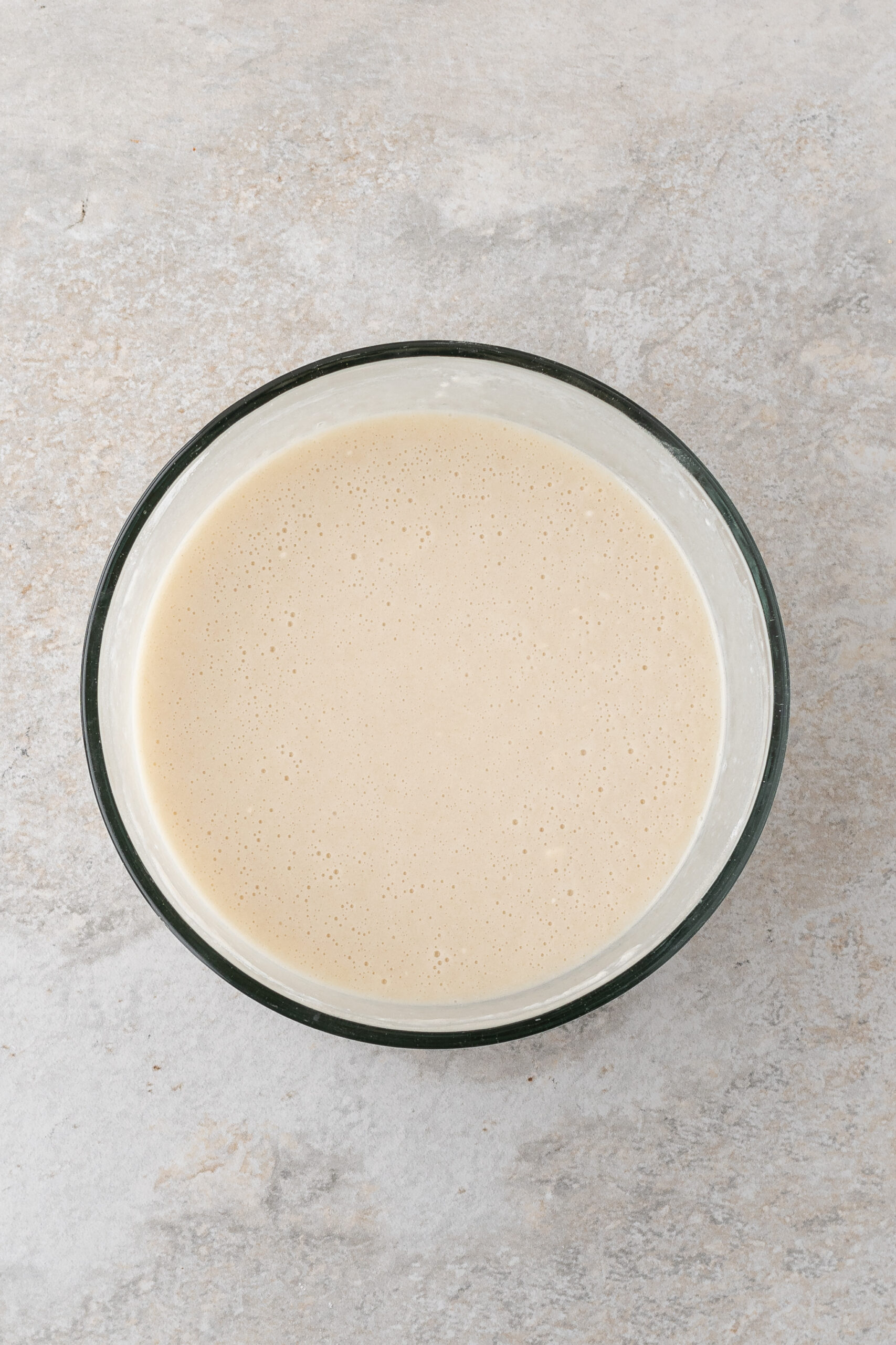 The milk mixture with vanilla bean is whisked and ready to be poured into the baking dish