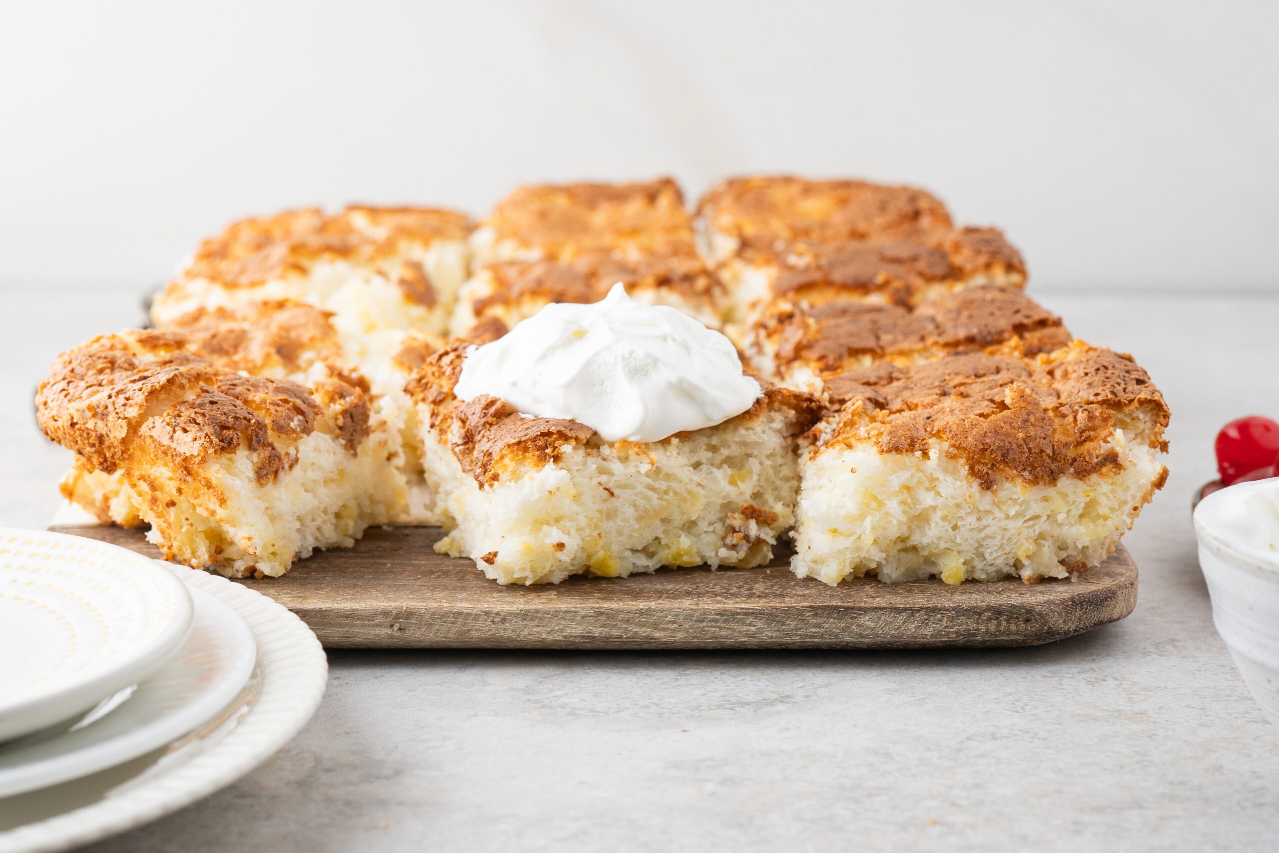 Cut squares of the finished angel food cake, one square has whip cream on top