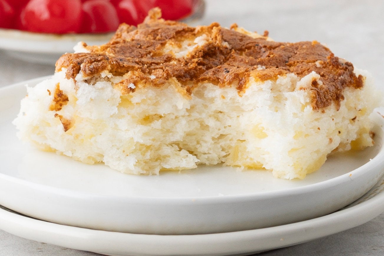 A side view with a bite taken out of the angel food cake to see its layers and textures