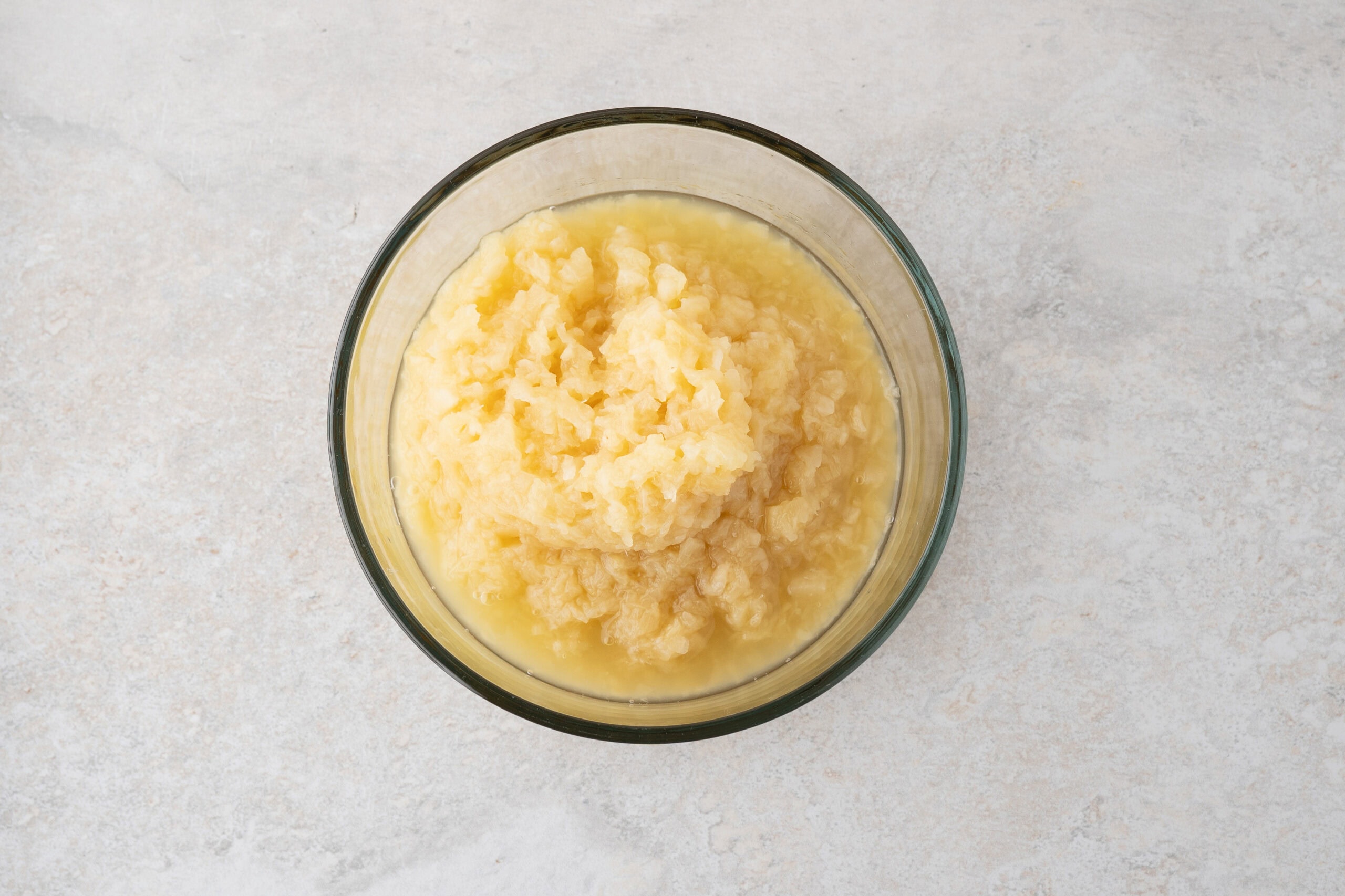 Crushed pineapple can in a mixing bowl, ready to add in the angel food cake mix