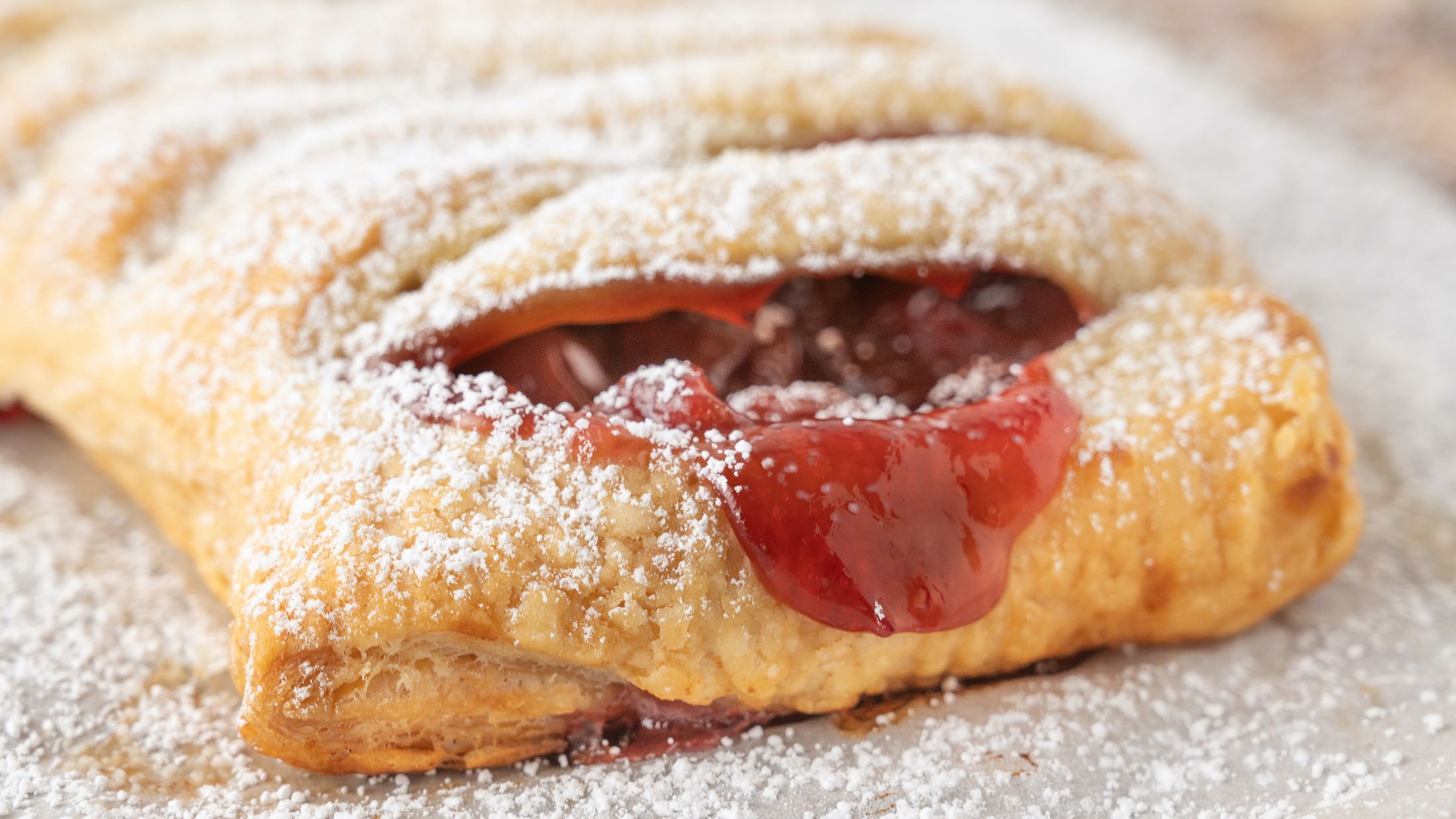 Baked puff pastry, just drizzled with sifted powdered sugar, ready to be sliced and enjoyed