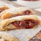 Close up puff pastry with cherry pie filling drizzling out
