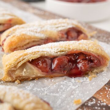 Close up puff pastry with cherry pie filling drizzling out