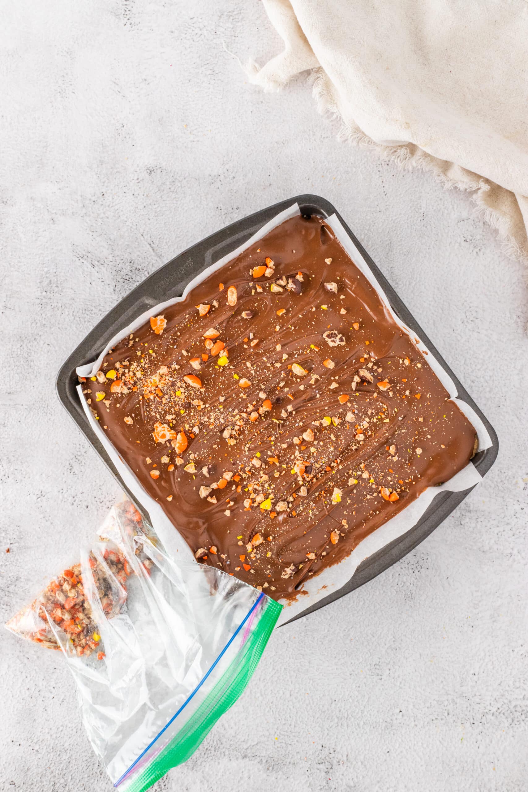 Adding the Rees's candies on top of the chocolate ganache