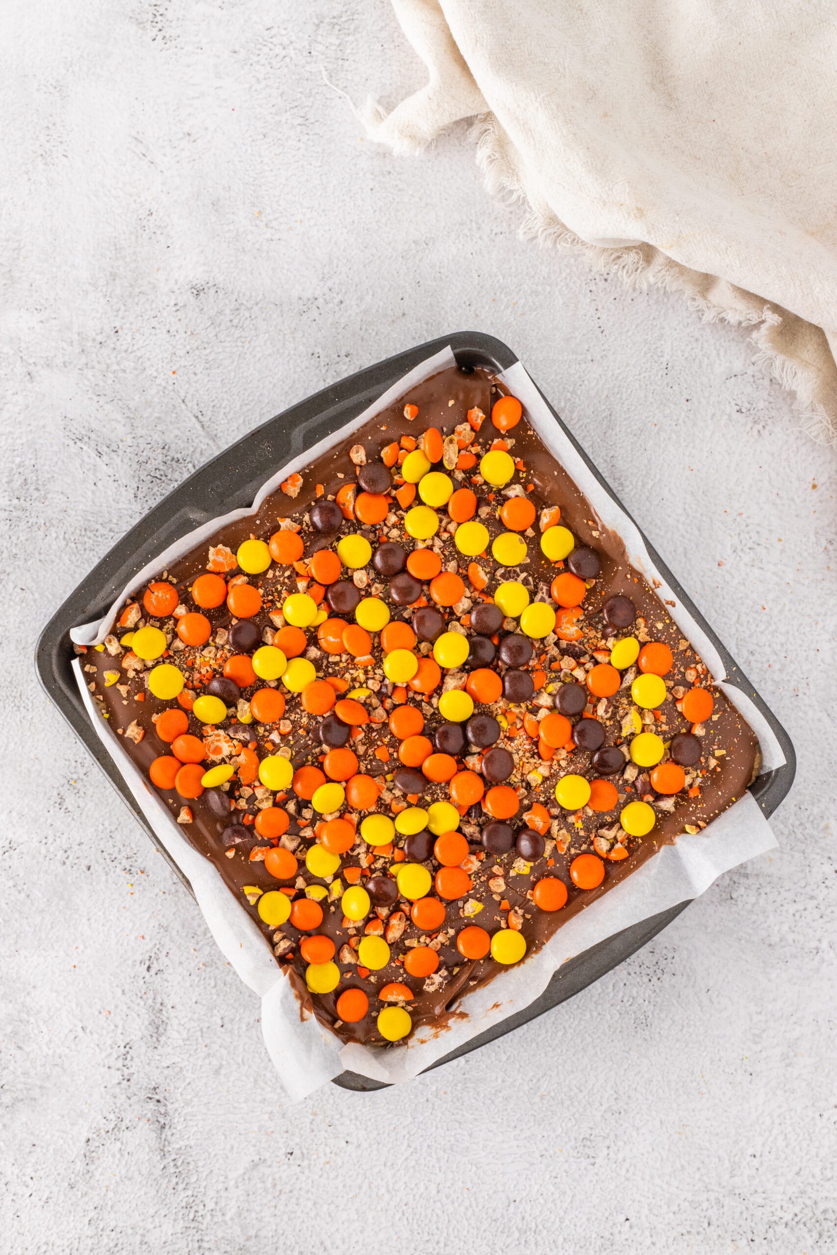 Sprinkling the crushed Reese's chocolates over the top of the Ganache.