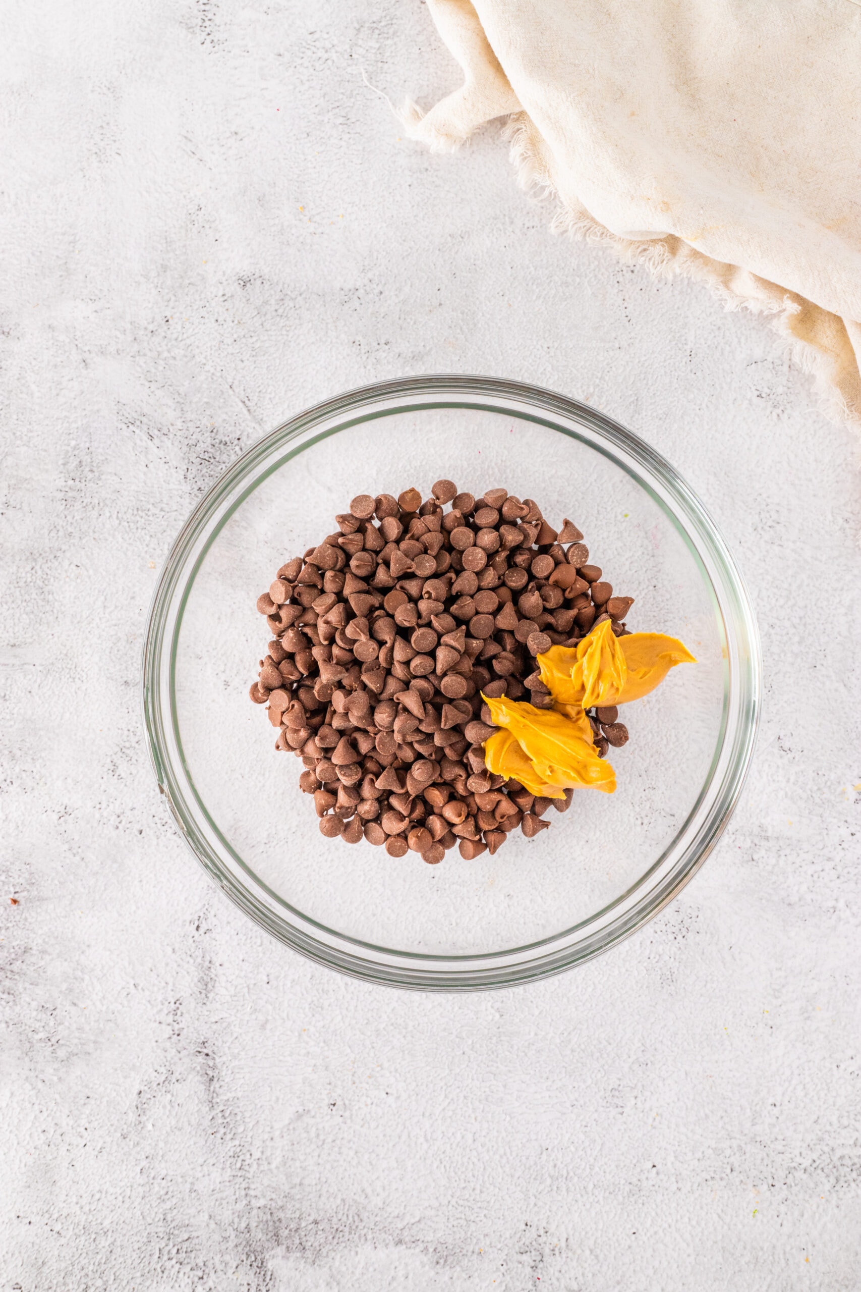 Adding Chocolate Chips and Peanut Butter to a microwave-safe bowl.