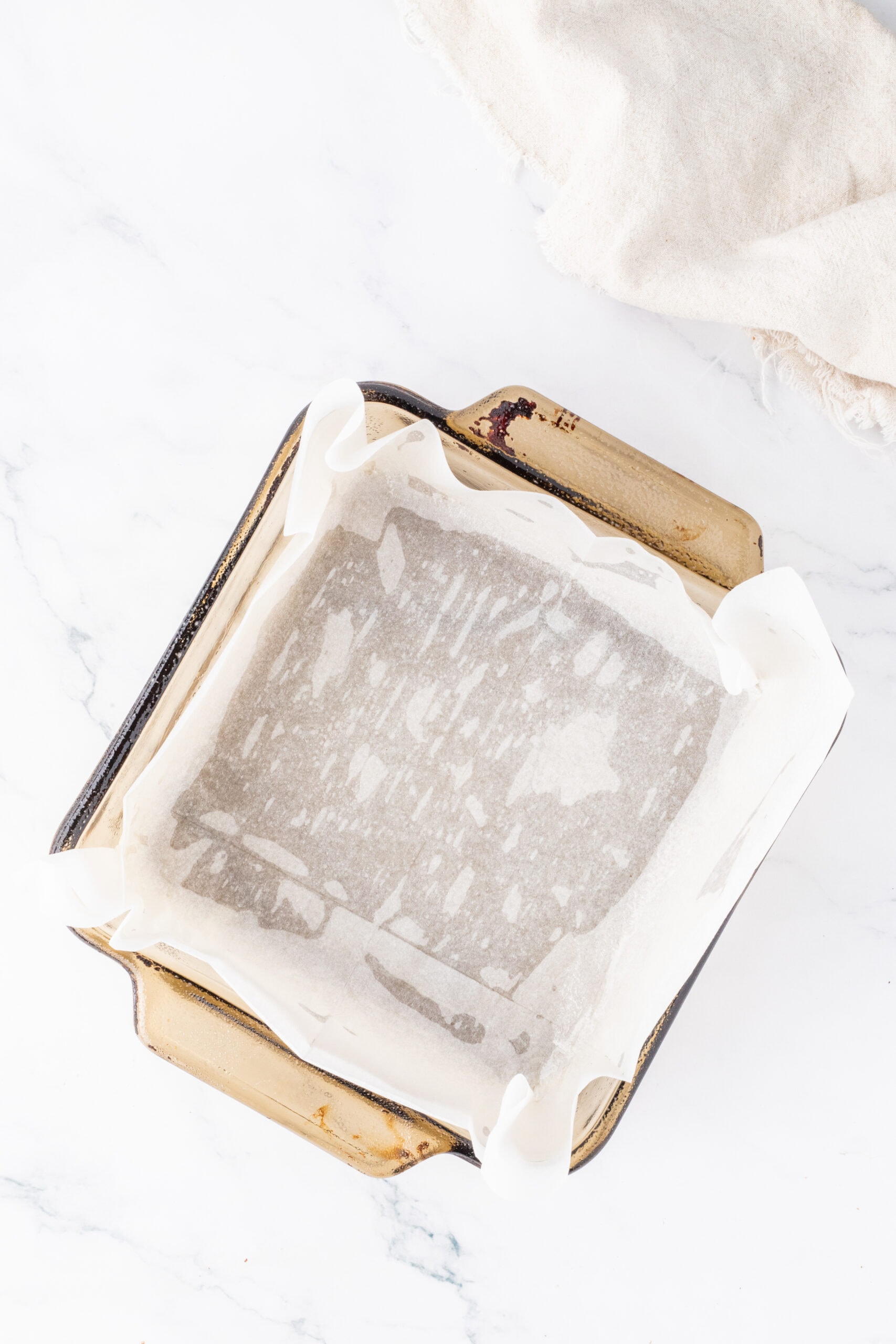 Prepared baking pan with parchment paper to add brownie batter