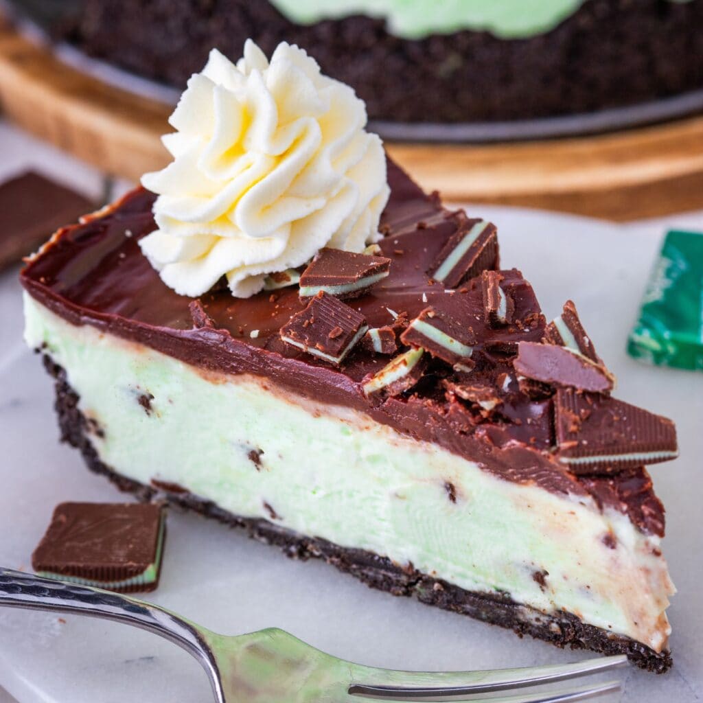 A slice of mint cheesecake on a plate with a fork