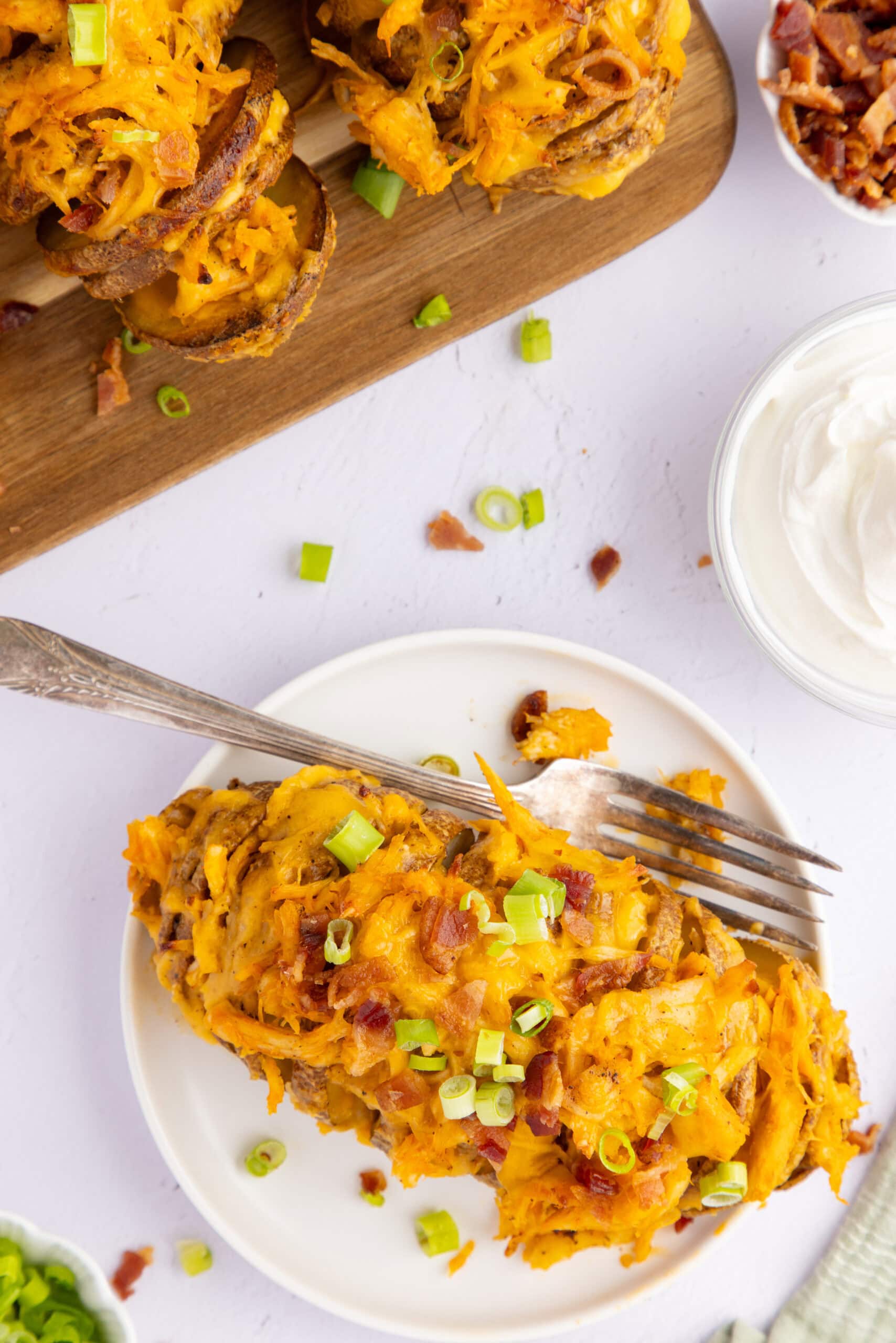 Stuffed potato on a plate, with bacon and green onion. Ready to be enjoyed