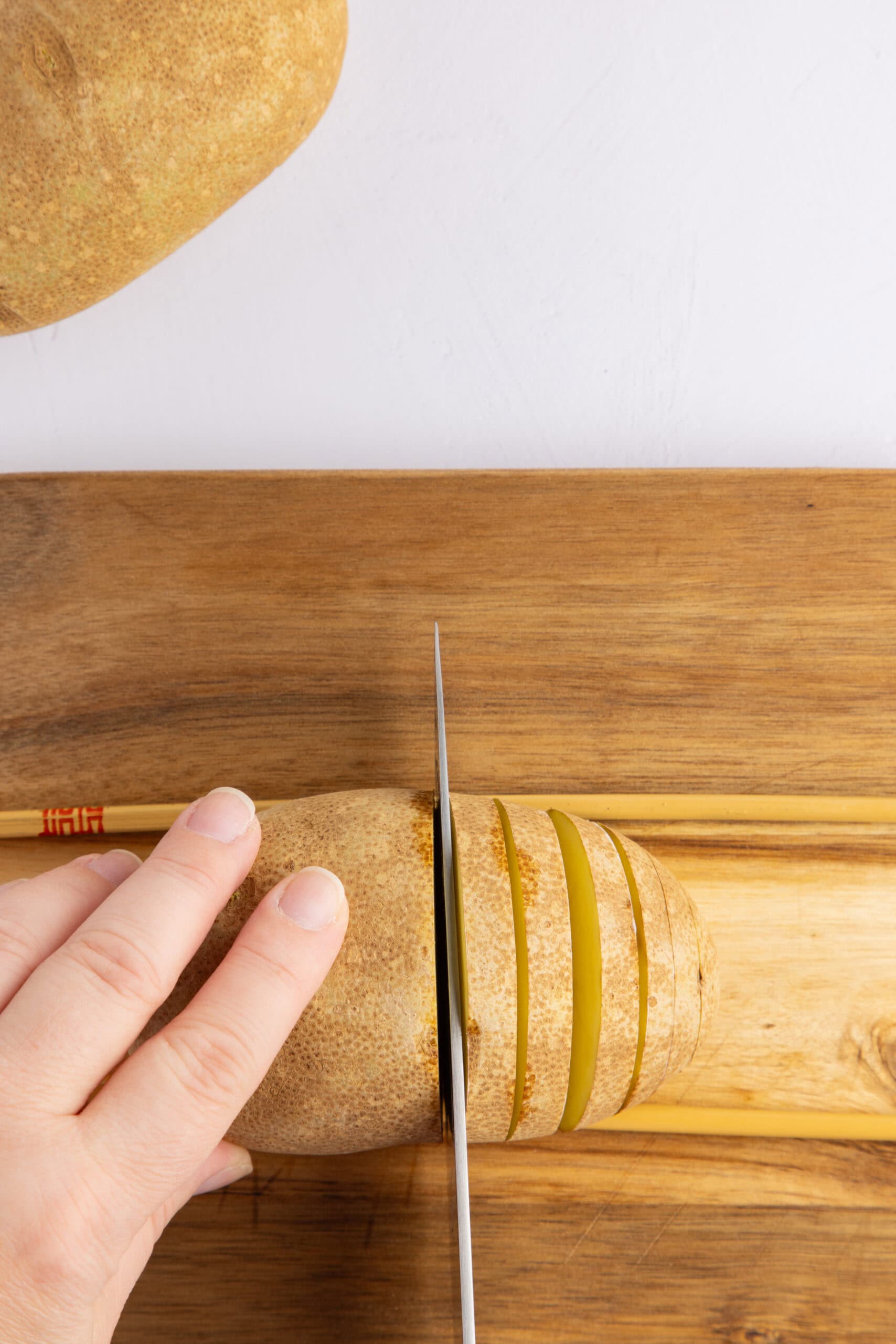 Slicing the potatoes in several slices, careful to not slice all the way down
