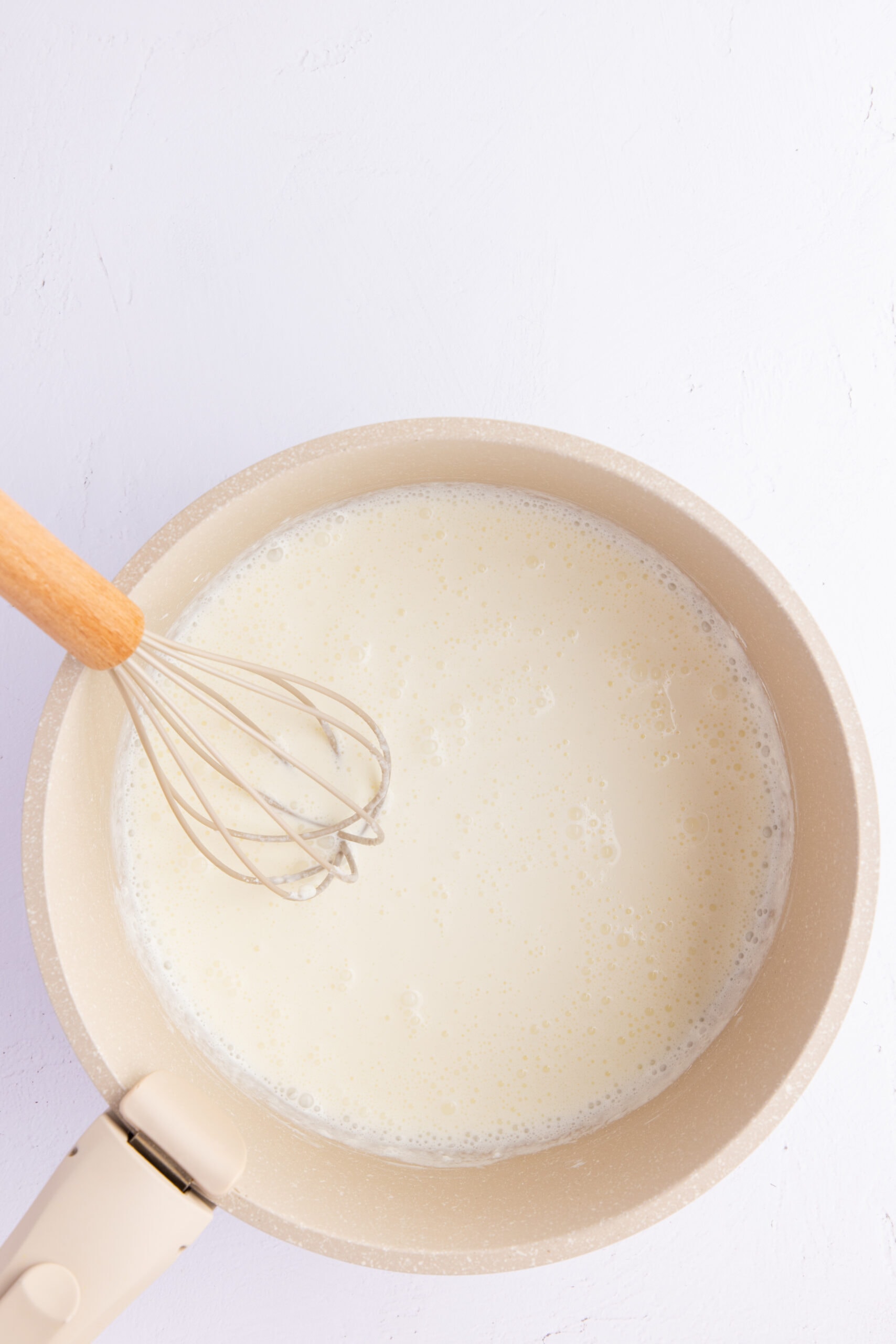Whisking cornstarch and heavy cream in a saucepan.