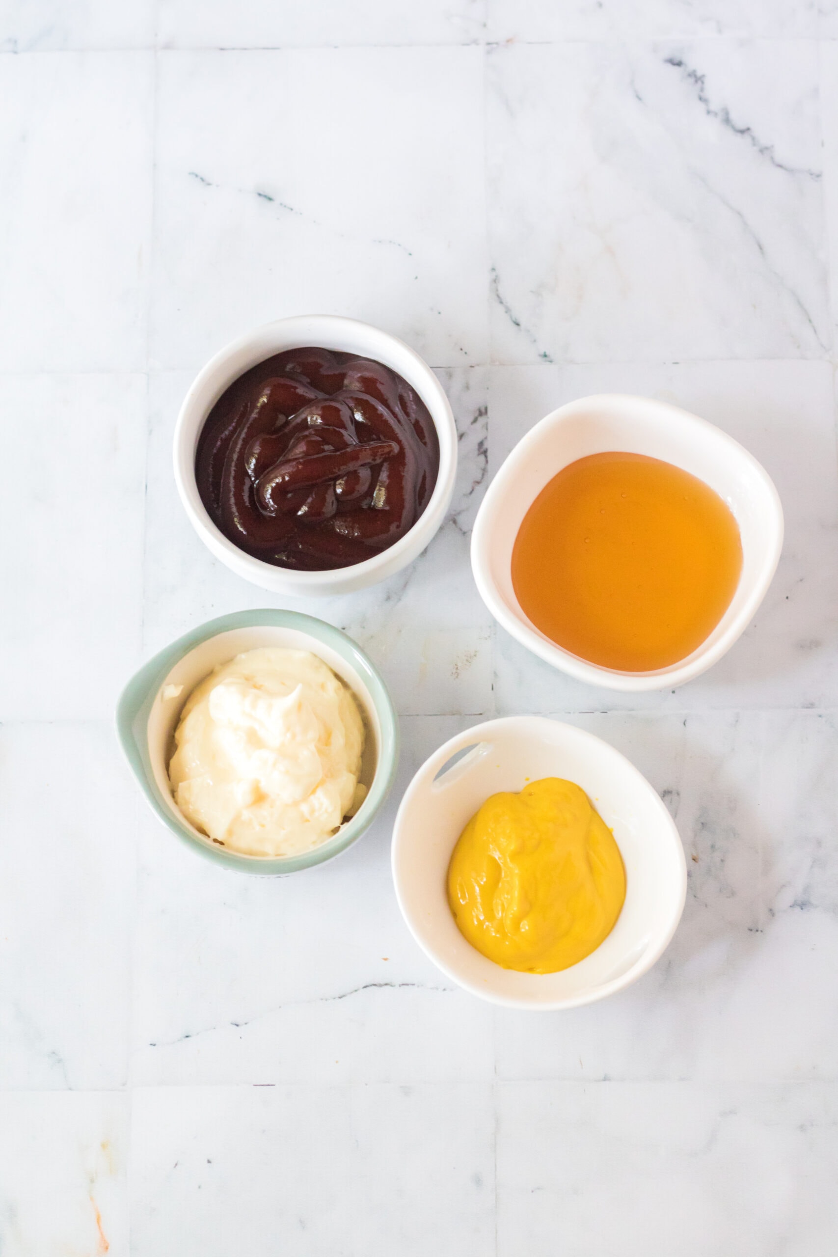 All ingredients to make Chick Fil A sauce: yellow mustard, mayo, bbq sauce and honey